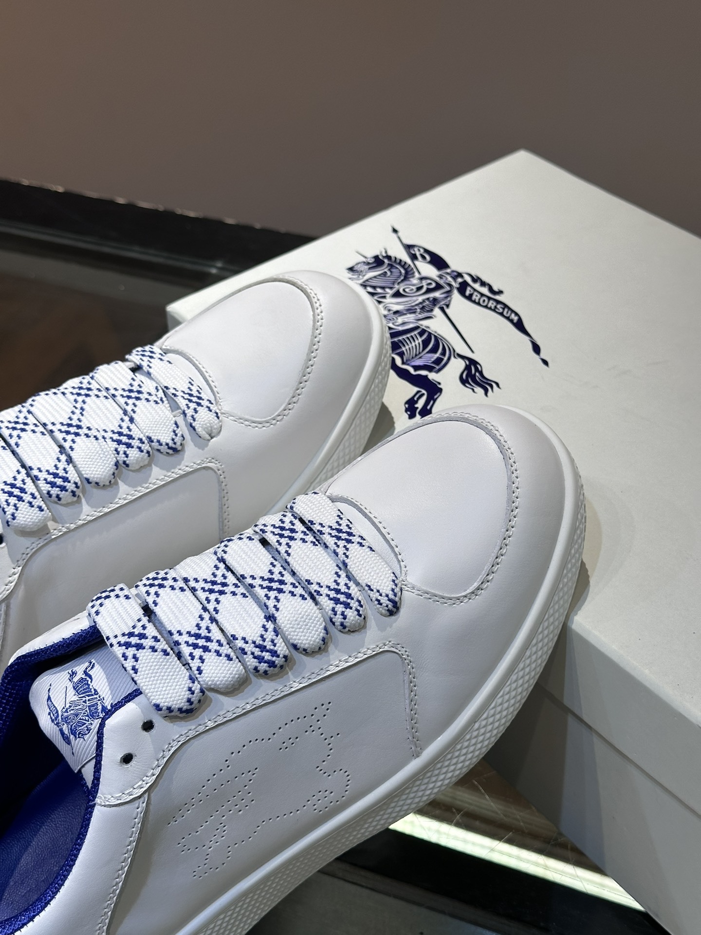 Burberry Stock leather sneakers feature a white calf leather upper, the Equestrian Knight Design perforated on the sides, and a rubber sole.