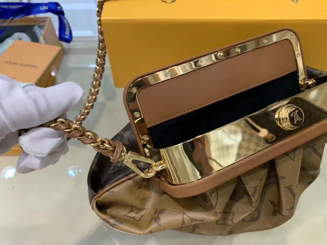 LV Boursicot EW bag is a vintage-inspired pouch crafted from monogram and reverse monogram coated canvas with leather-covered frame details