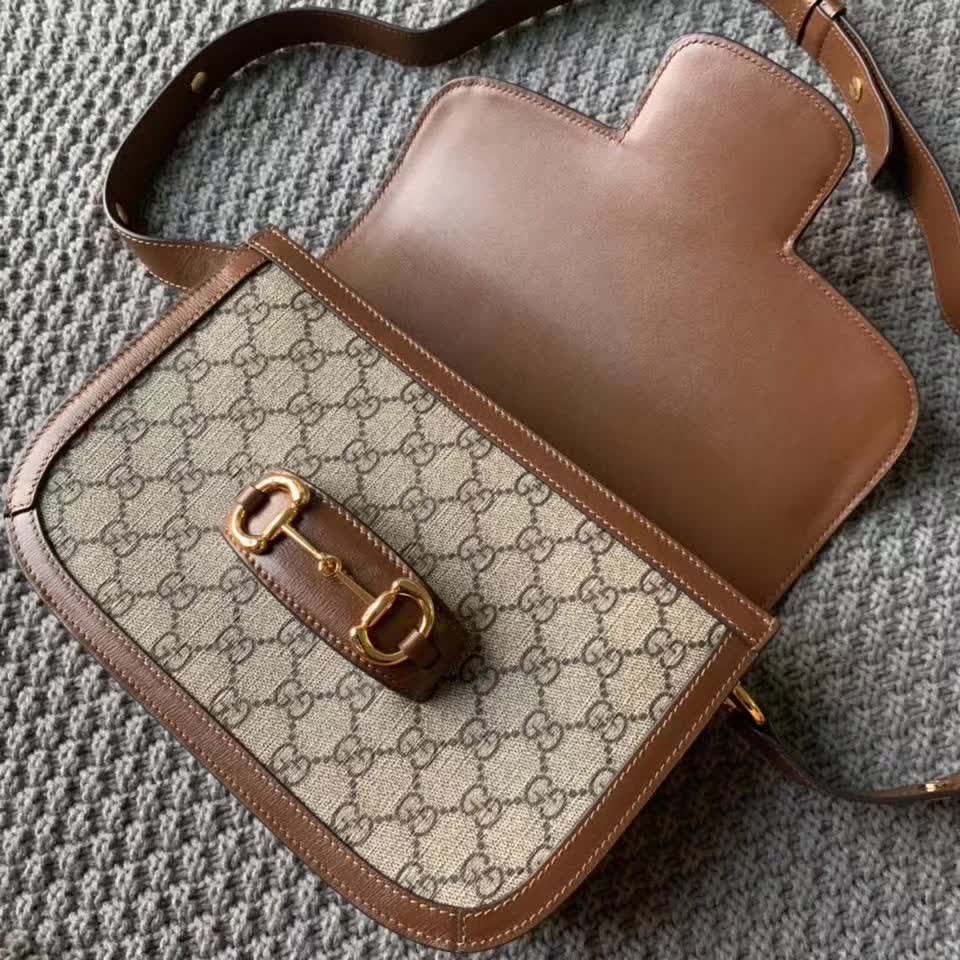 Gucci Horsebit 1955 shoulder bag, featuring the brand's iconic GG monogram canvas with brown leather trim and gold-tone horsebit hardware
