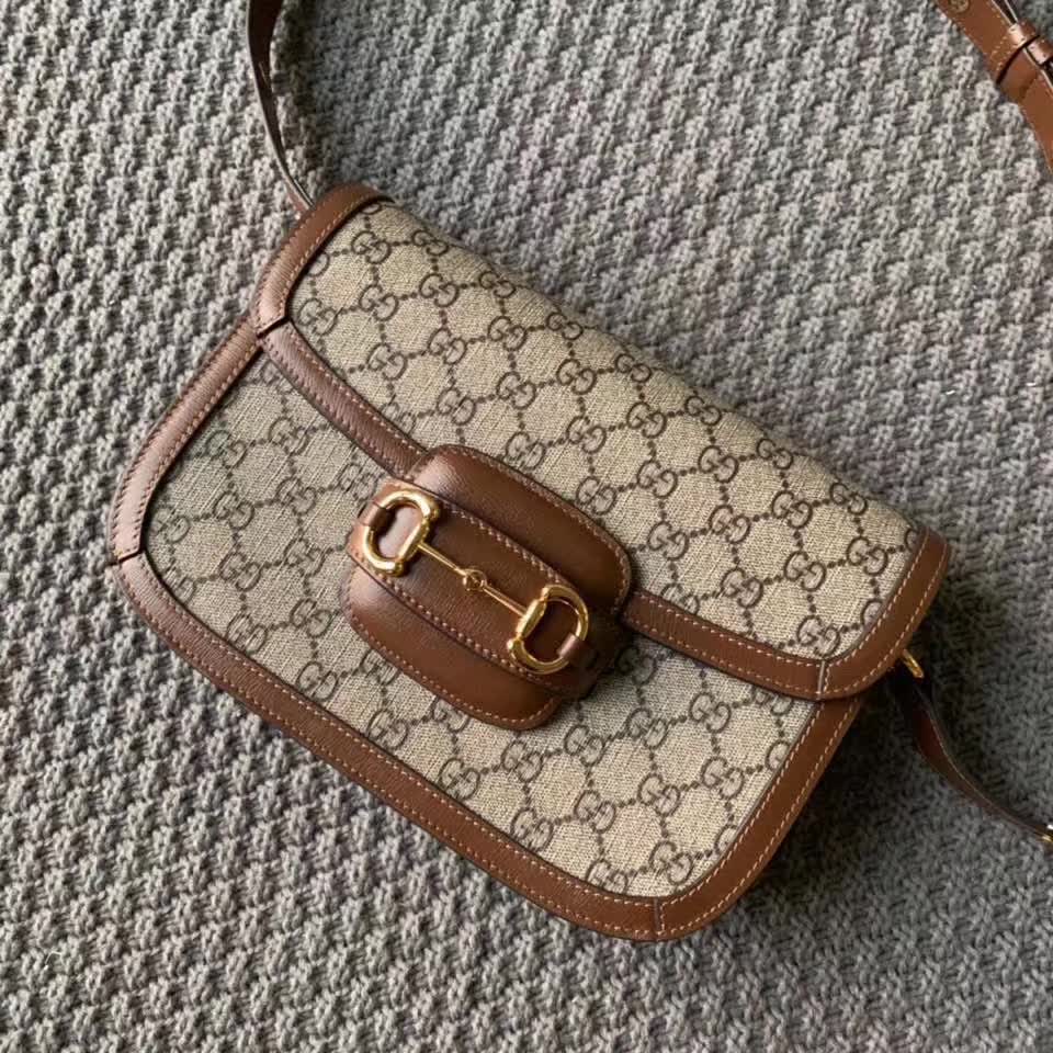 Gucci Horsebit 1955 shoulder bag, featuring the brand's iconic GG monogram canvas with brown leather trim and gold-tone horsebit hardware