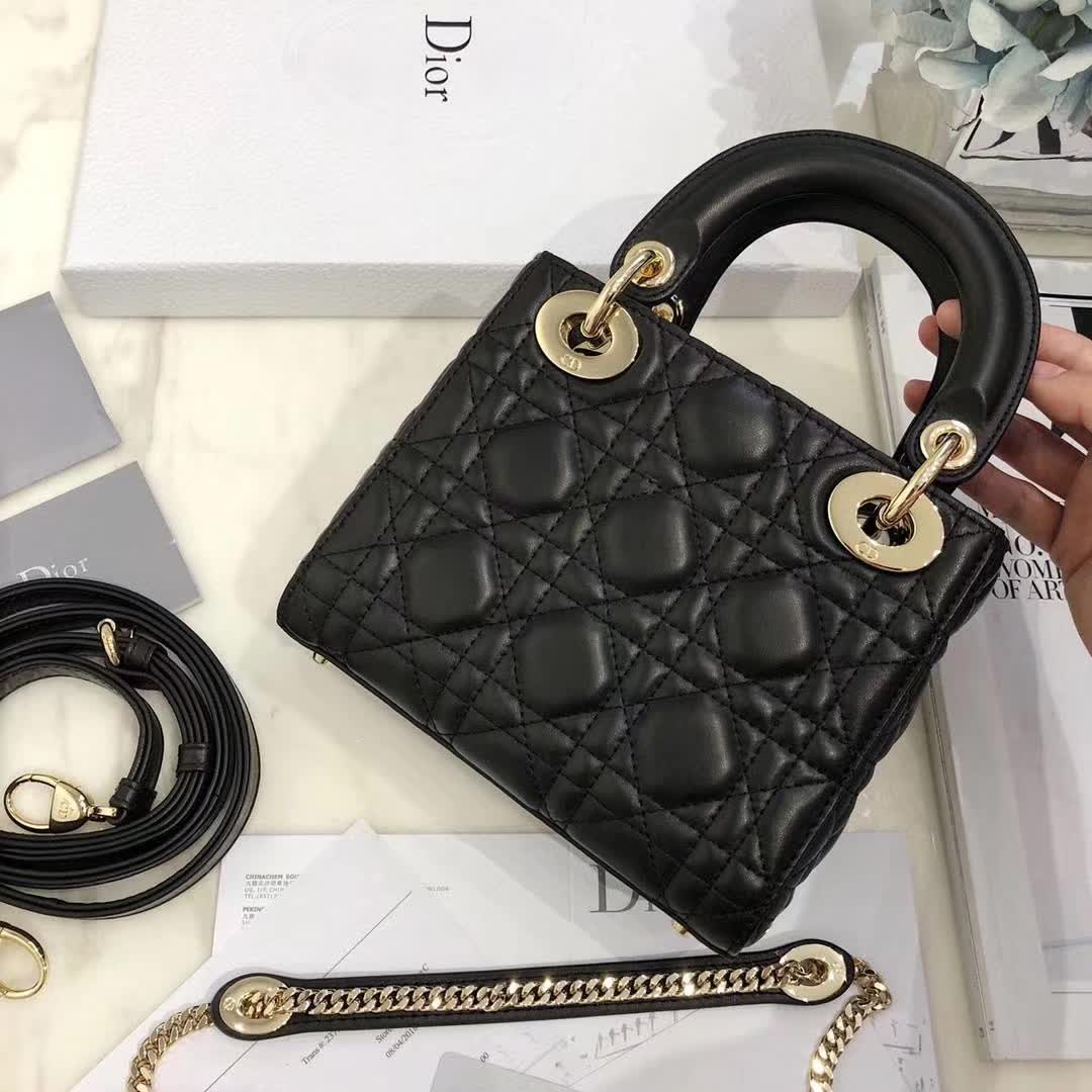 christian dior black quilted lambskin leather Lady Dior bag featuring distinctive Cannage stitching and pale gold-finish metal D.I.O.R. charms