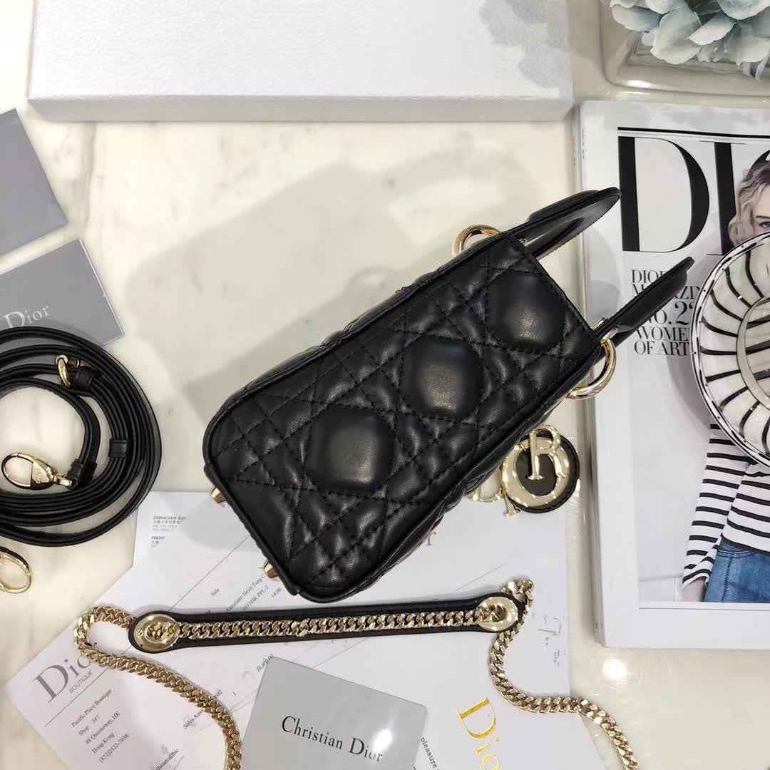 christian dior black quilted lambskin leather Lady Dior bag featuring distinctive Cannage stitching and pale gold-finish metal D.I.O.R. charms