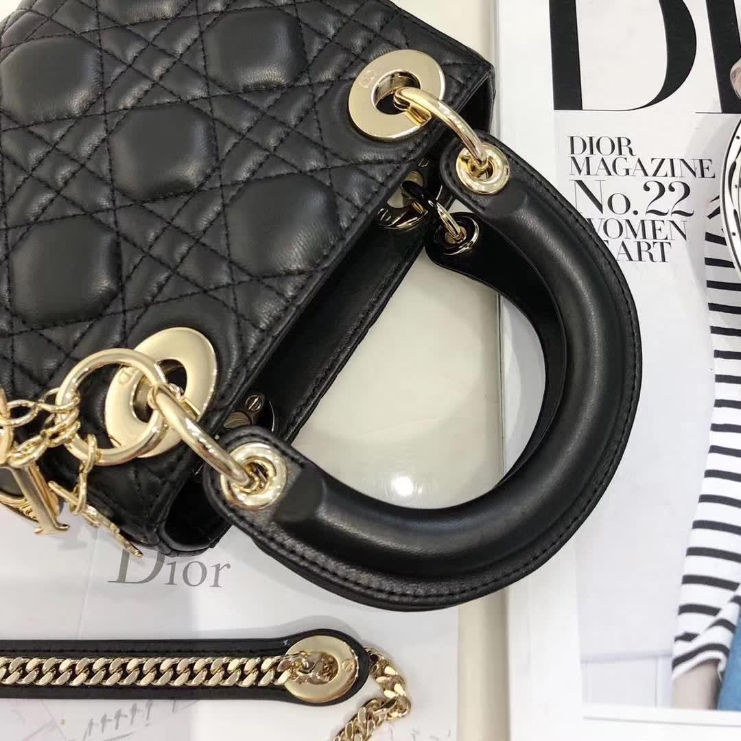 christian dior black quilted lambskin leather Lady Dior bag featuring distinctive Cannage stitching and pale gold-finish metal D.I.O.R. charms