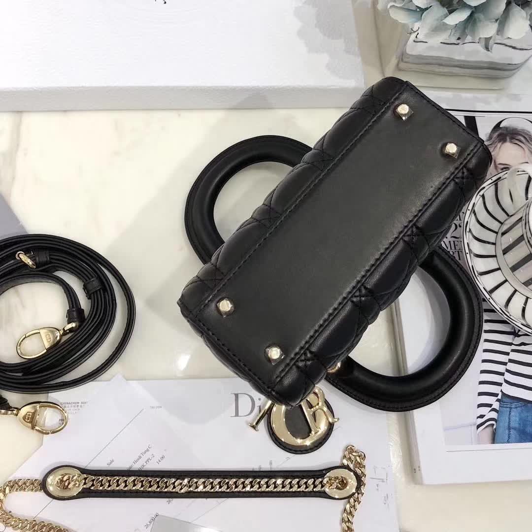 christian dior black quilted lambskin leather Lady Dior bag featuring distinctive Cannage stitching and pale gold-finish metal D.I.O.R. charms