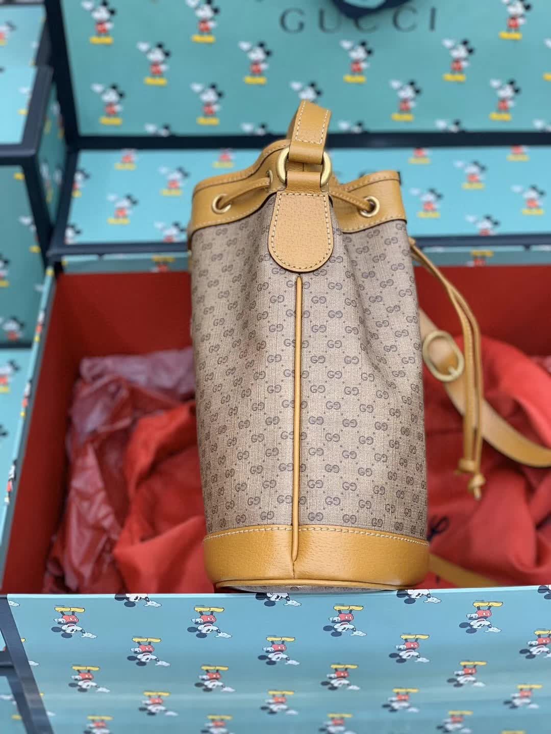 Gucci x Disney Mini GG Supreme Bucket Bag featuring a Mickey Mouse print