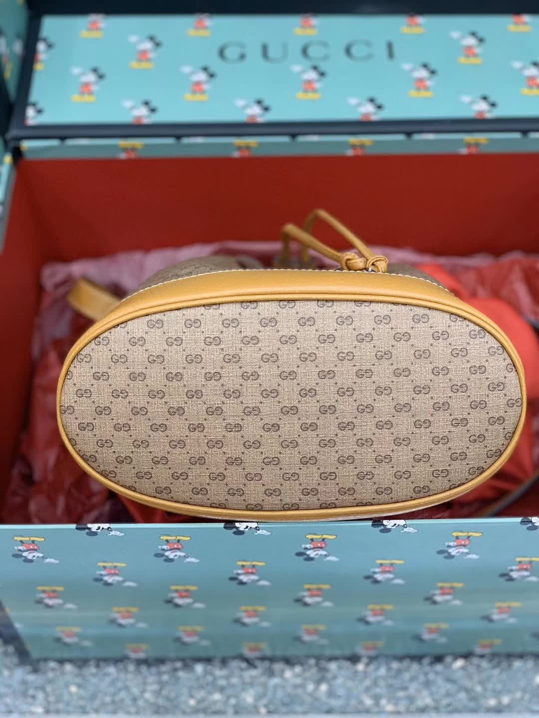 Gucci x Disney Mini GG Supreme Bucket Bag featuring a Mickey Mouse print