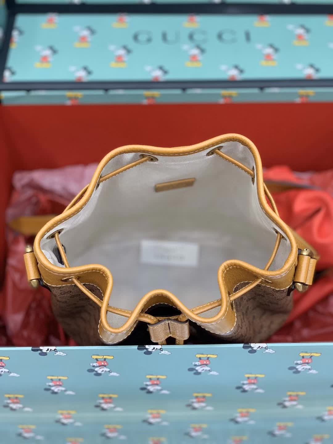 Gucci x Disney Mini GG Supreme Bucket Bag featuring a Mickey Mouse print