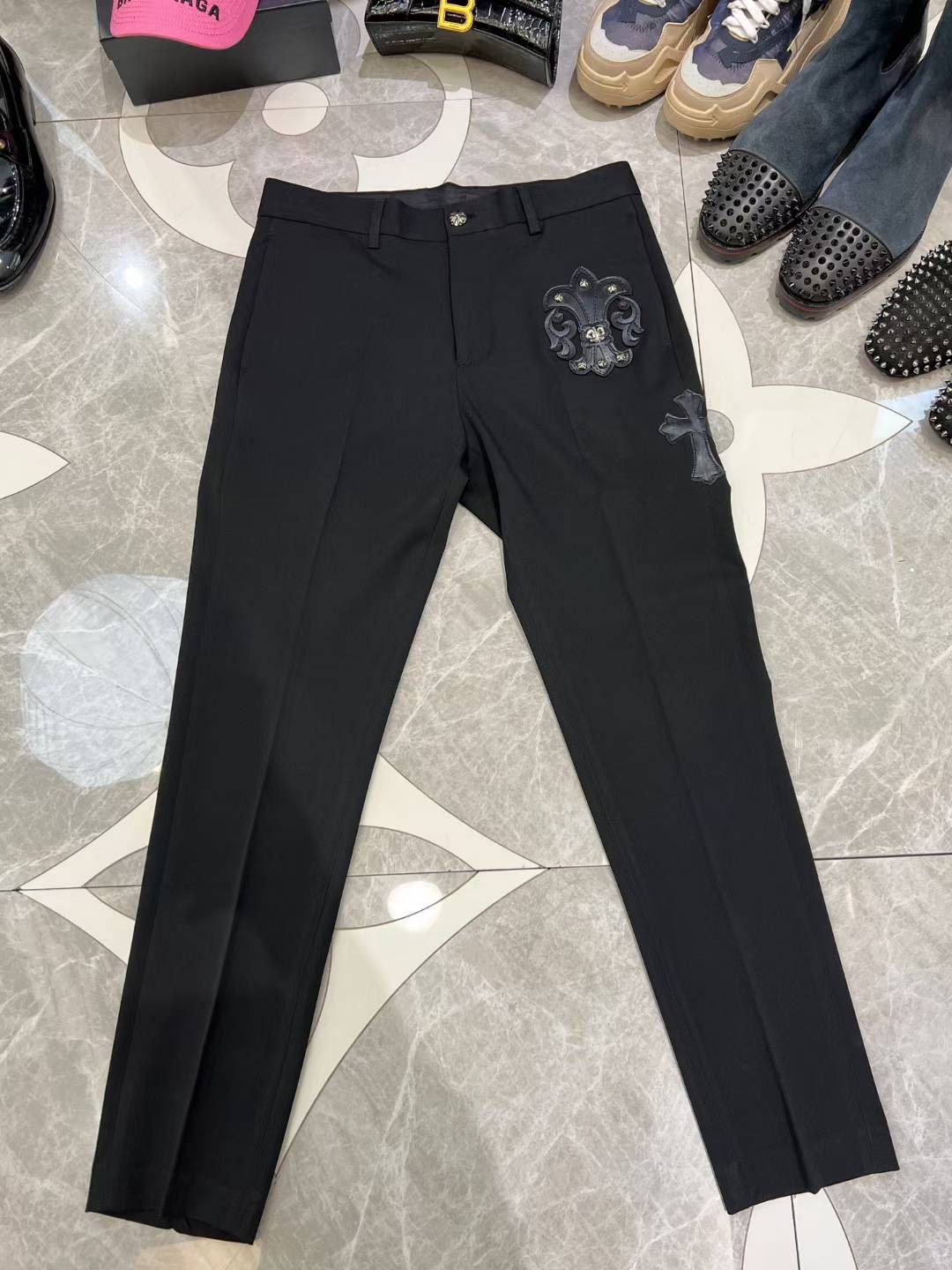 chrome hearts black trousers feature decorative patches and embroidery resembling a luxury designer pair such as those from Philipp Plein