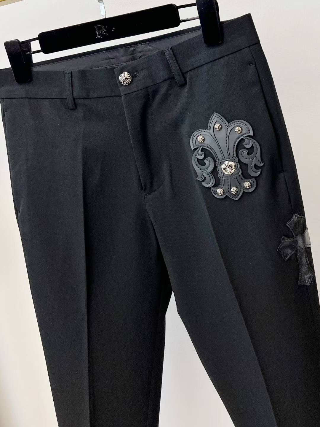 chrome hearts black trousers feature decorative patches and embroidery resembling a luxury designer pair such as those from Philipp Plein