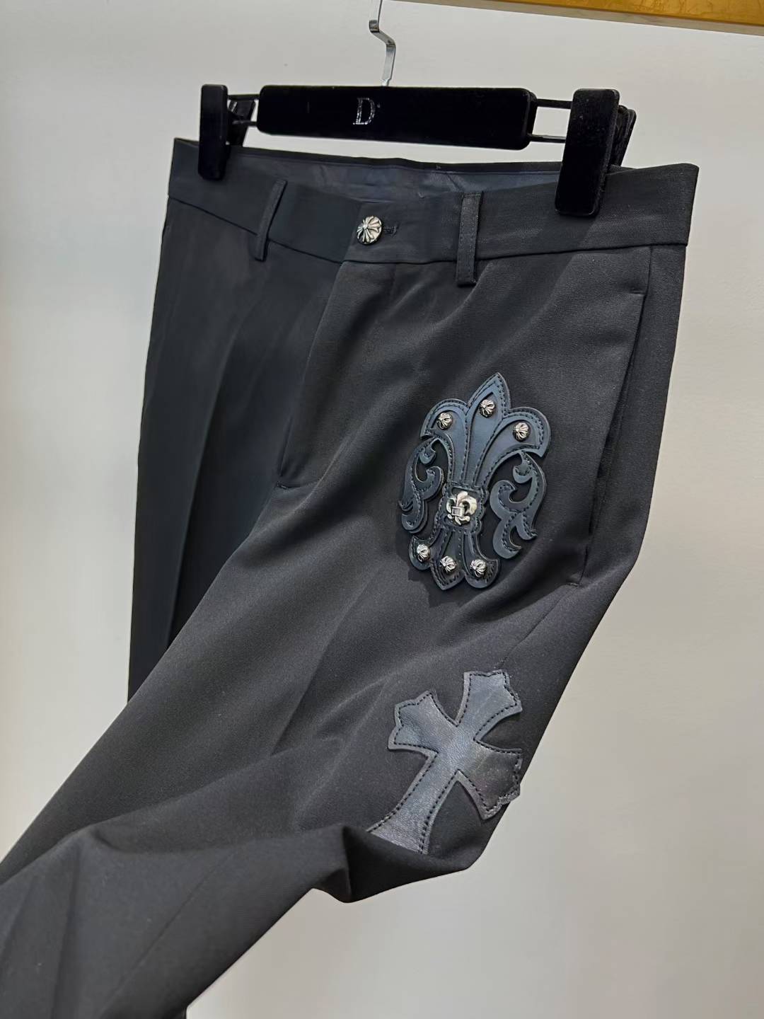 chrome hearts black trousers feature decorative patches and embroidery resembling a luxury designer pair such as those from Philipp Plein