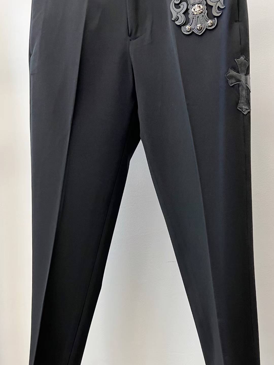 chrome hearts black trousers feature decorative patches and embroidery resembling a luxury designer pair such as those from Philipp Plein