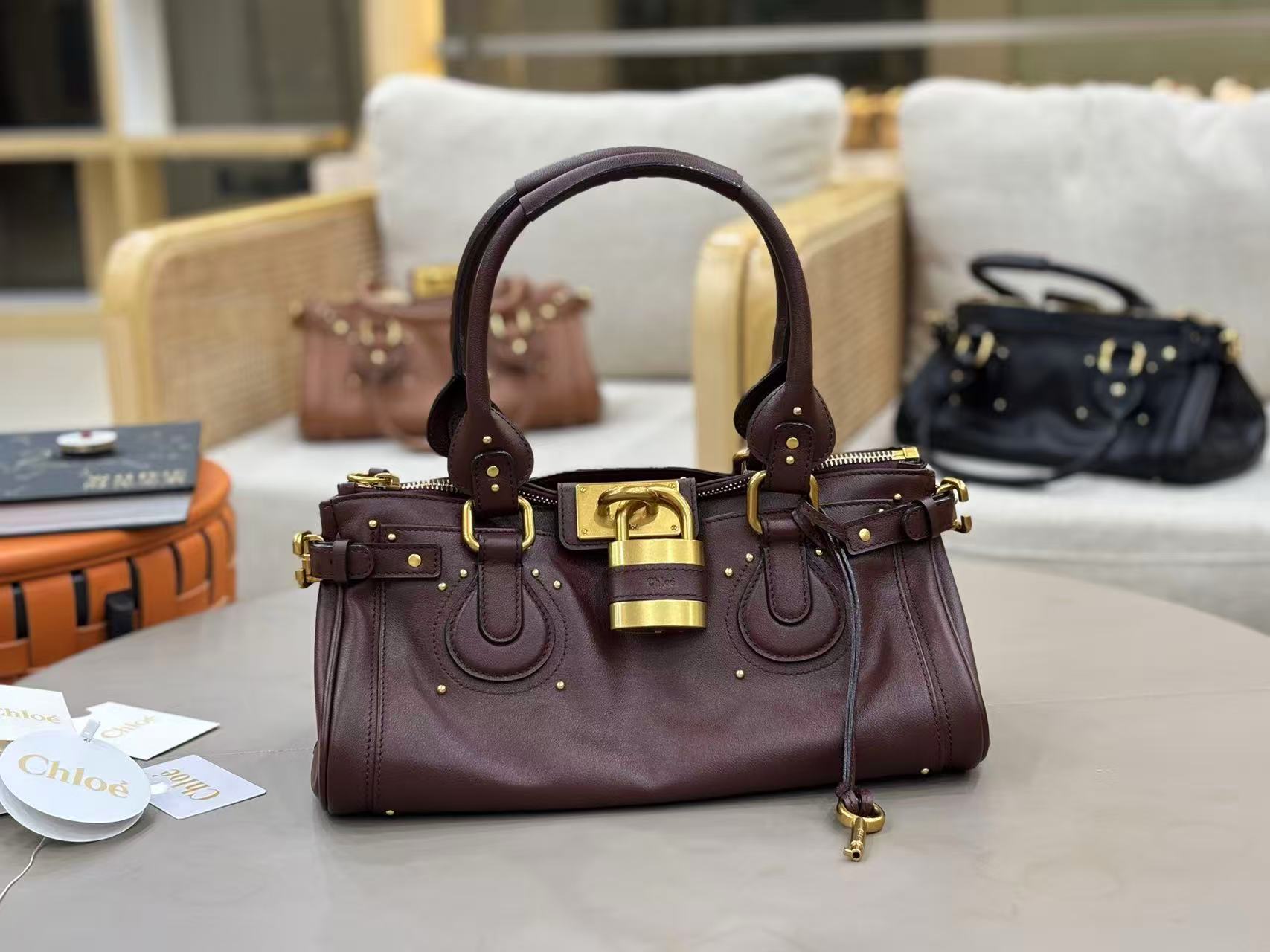Chloe Paddington bag in Crafty Brown featuring the signature oversized gold padlock, dual top handles, and grained buffalo leather