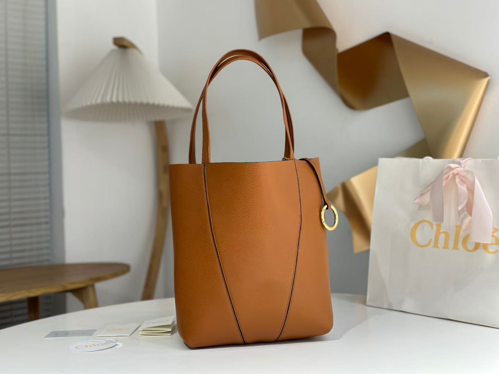 Chloe Small Spin Tote Bag, crafted from grained leather and featuring a distinctive dangling charm.