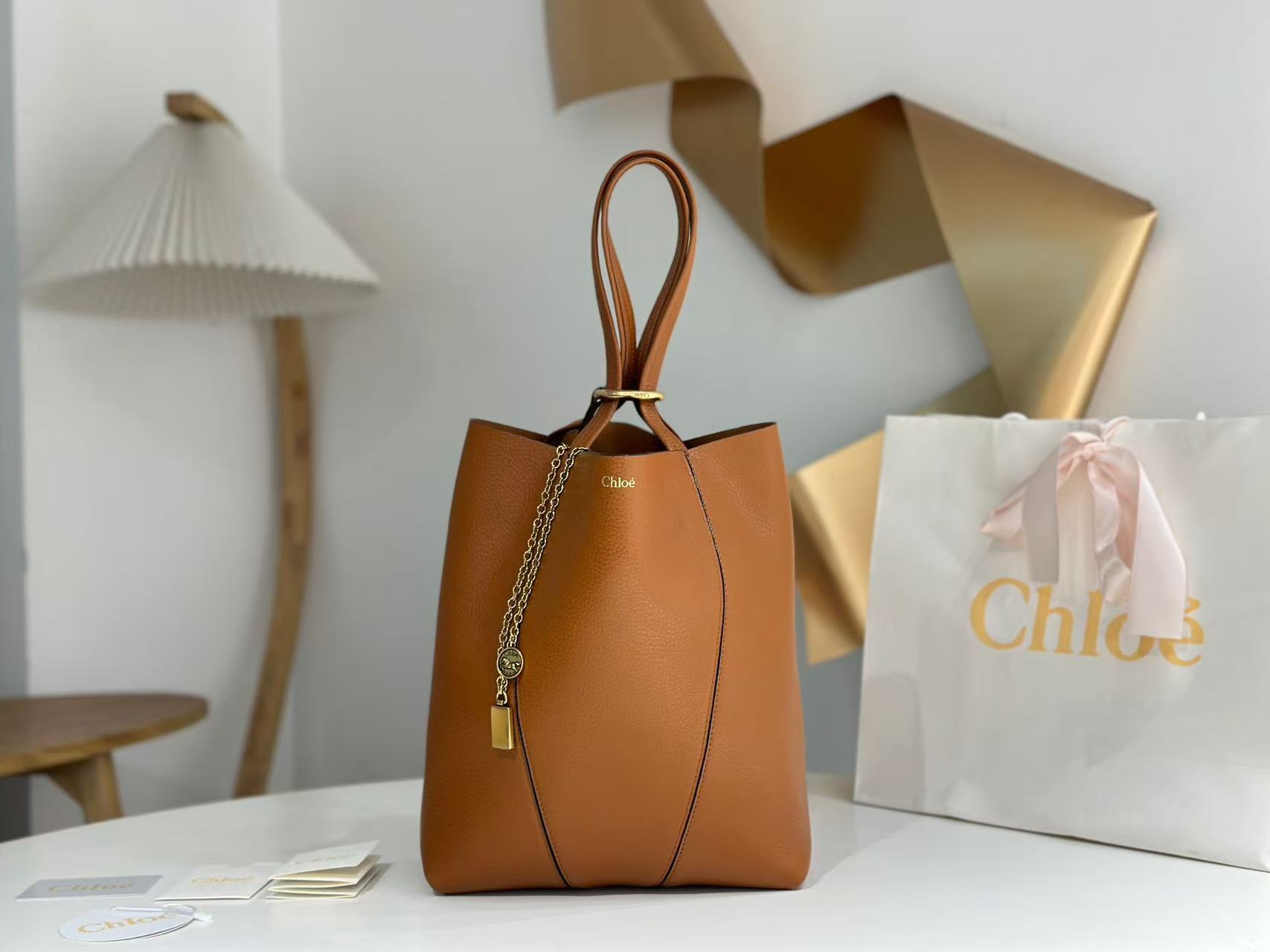 Chloe Small Spin Tote Bag, crafted from grained leather and featuring a distinctive dangling charm.