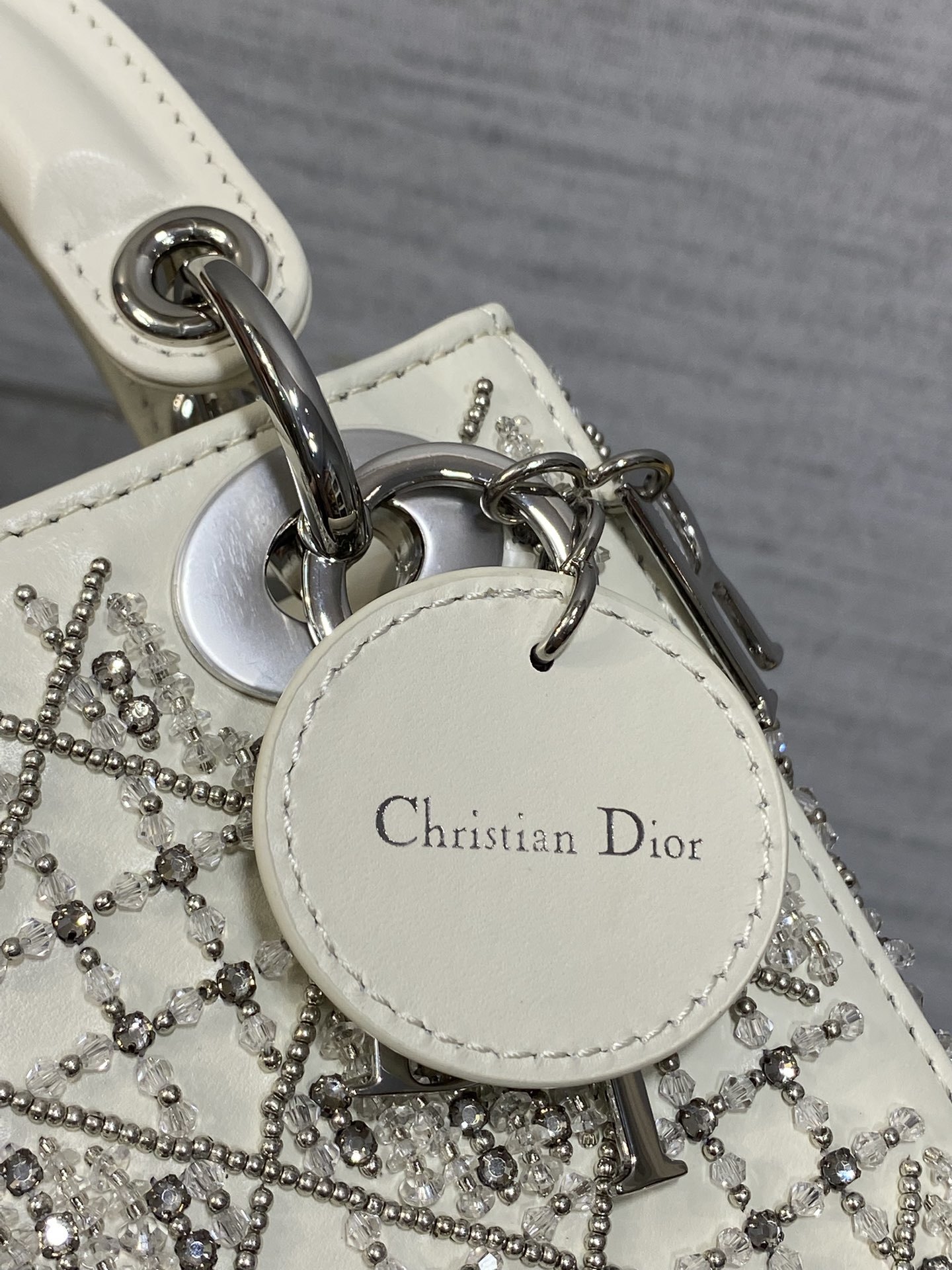 Dior Mini Lady Dior bag is crafted latte-colored beaded lambskin with silver rhinestone