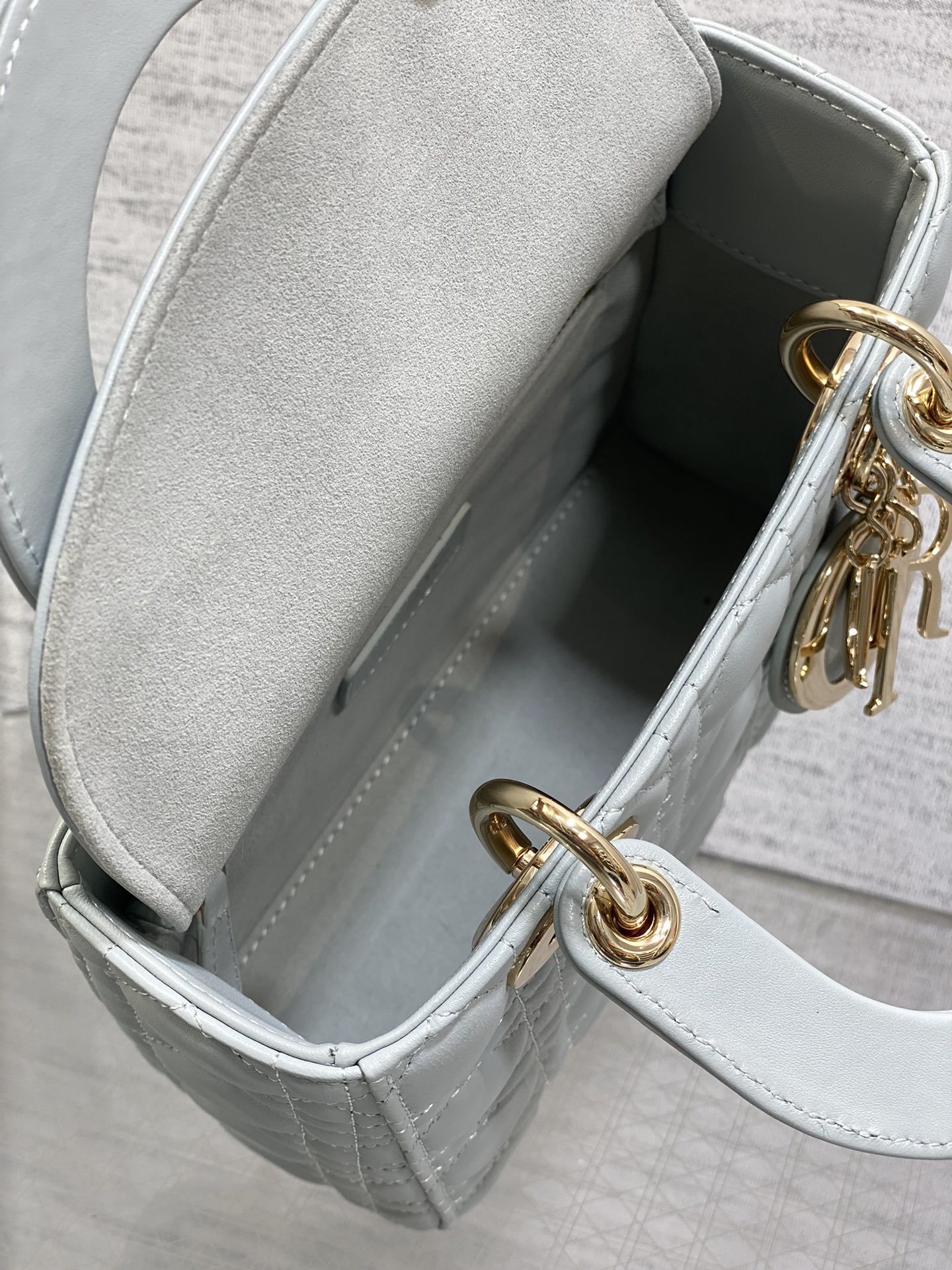 Dior Small Lady Dior My ABCDior Bag typically crafted in cannage lambskin with customizable charms on the strap.