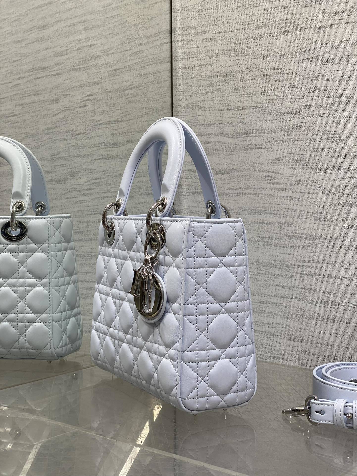 Dior Small Lady Dior Bag in white lambskin, featuring the iconic Cannage quilting pattern and customizable shoulder strap.