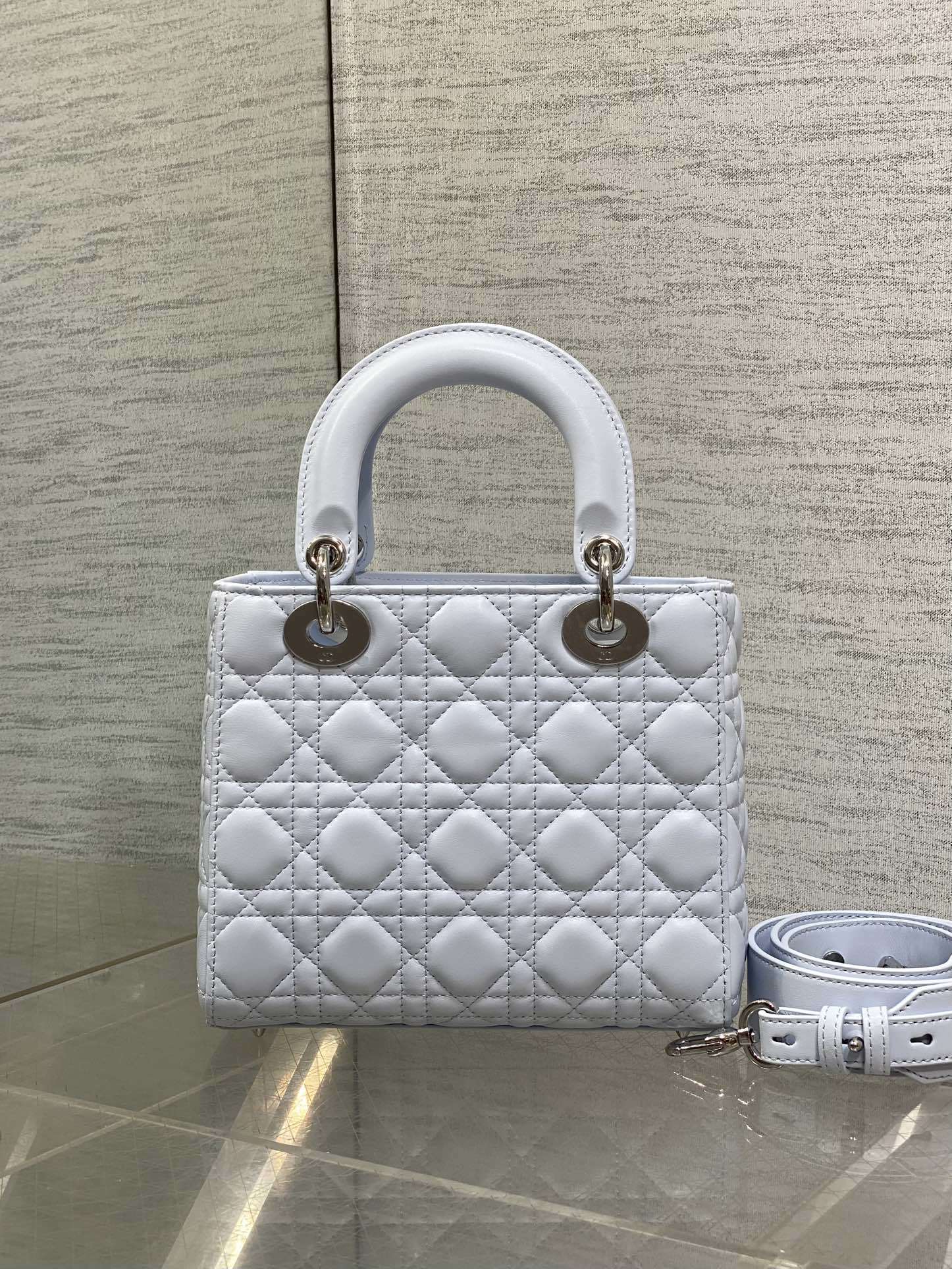 Dior Small Lady Dior Bag in white lambskin, featuring the iconic Cannage quilting pattern and customizable shoulder strap.