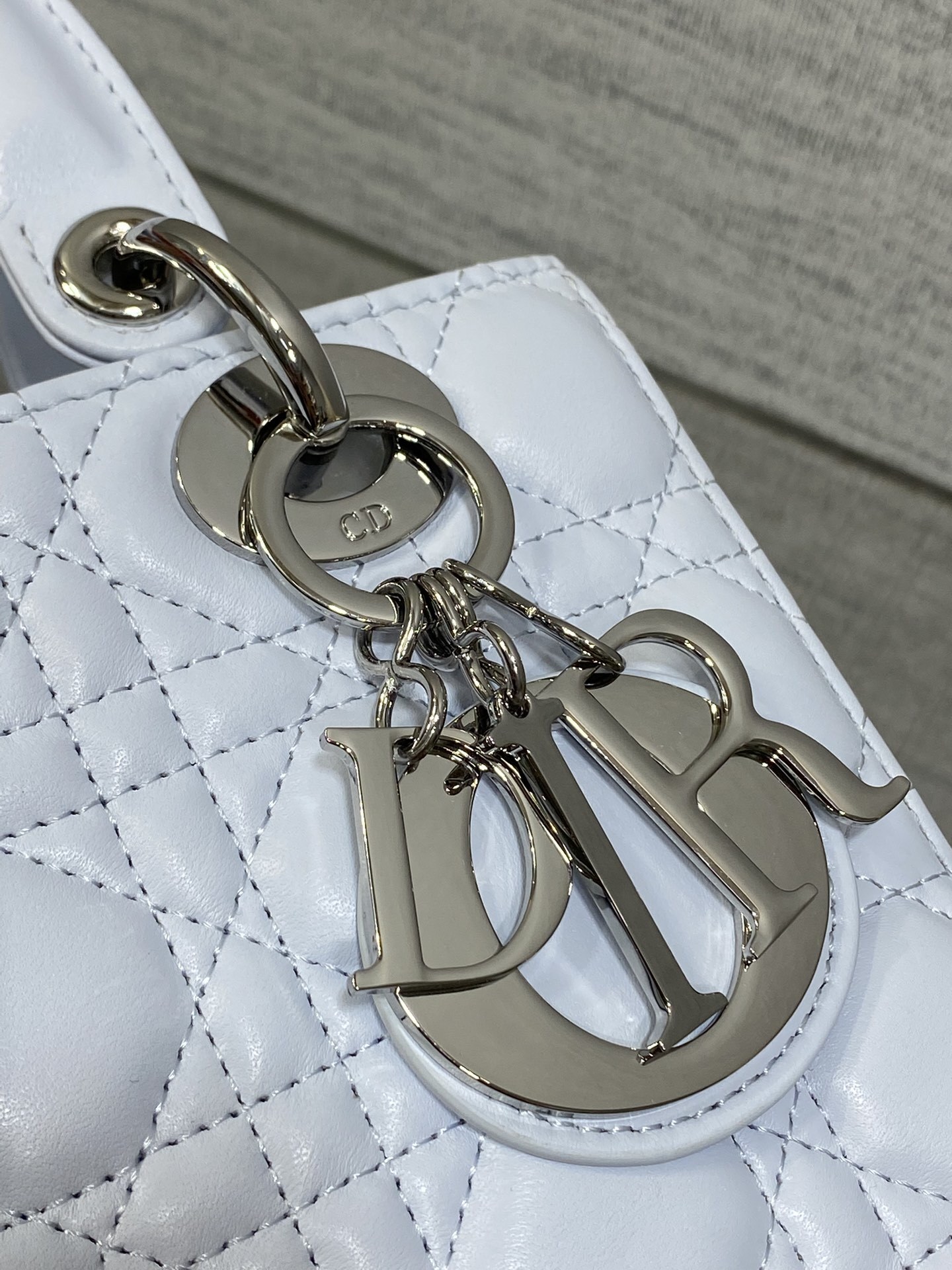 Dior Small Lady Dior Bag in white lambskin, featuring the iconic Cannage quilting pattern and customizable shoulder strap.