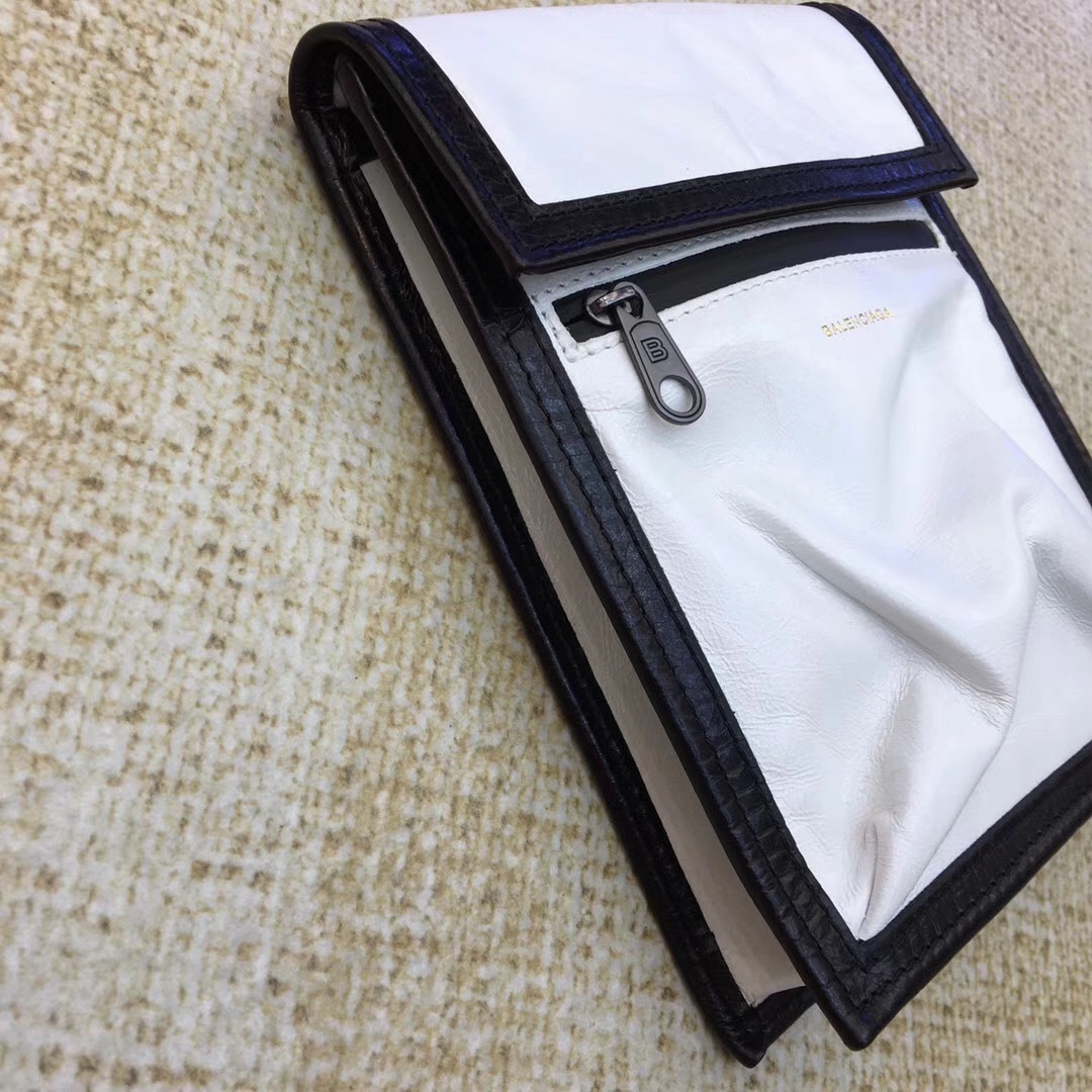 Balenciaga white and black Kenzo phone holder featuring a magnetic closure, an adjustable strap, and an external zip pocket.