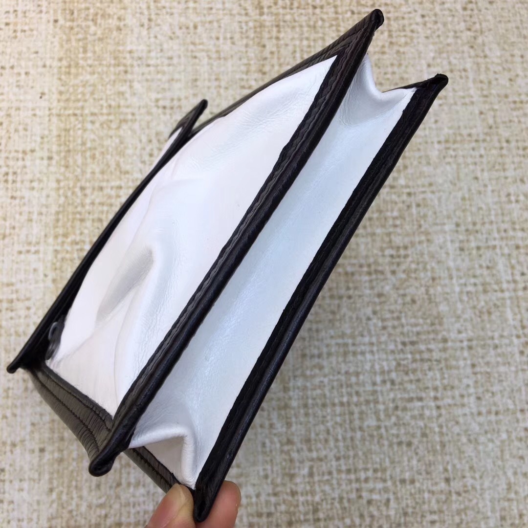 Balenciaga white and black Kenzo phone holder featuring a magnetic closure, an adjustable strap, and an external zip pocket.