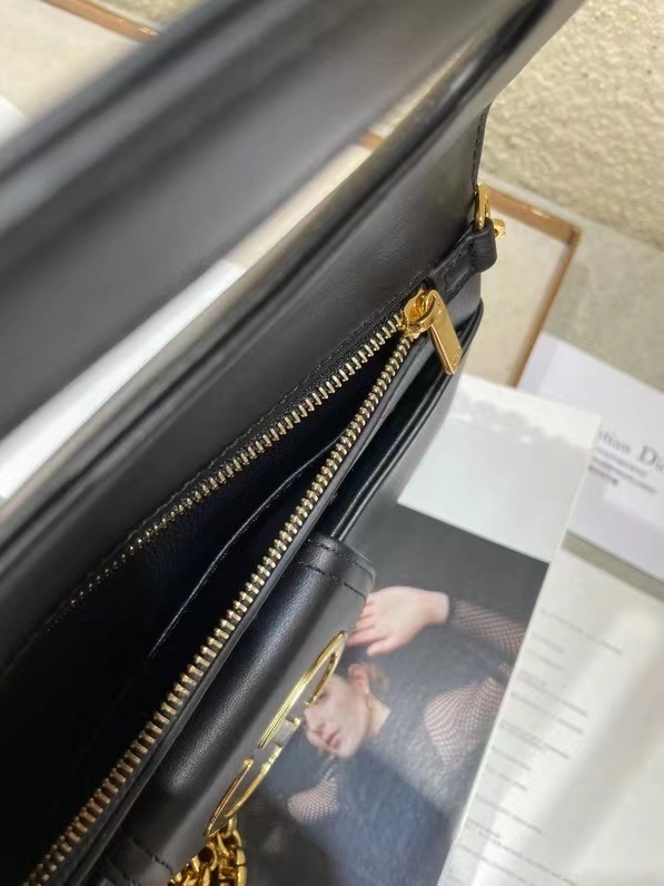 Dior Double bag crafted from black calfskin leather, characterized by its distinctive front flap design and gold-tone hardware