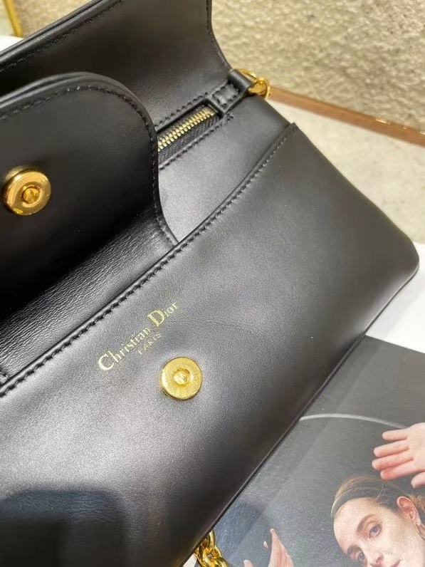 Dior Double bag crafted from black calfskin leather, characterized by its distinctive front flap design and gold-tone hardware