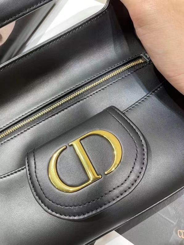 Dior Double bag crafted from black calfskin leather, characterized by its distinctive front flap design and gold-tone hardware