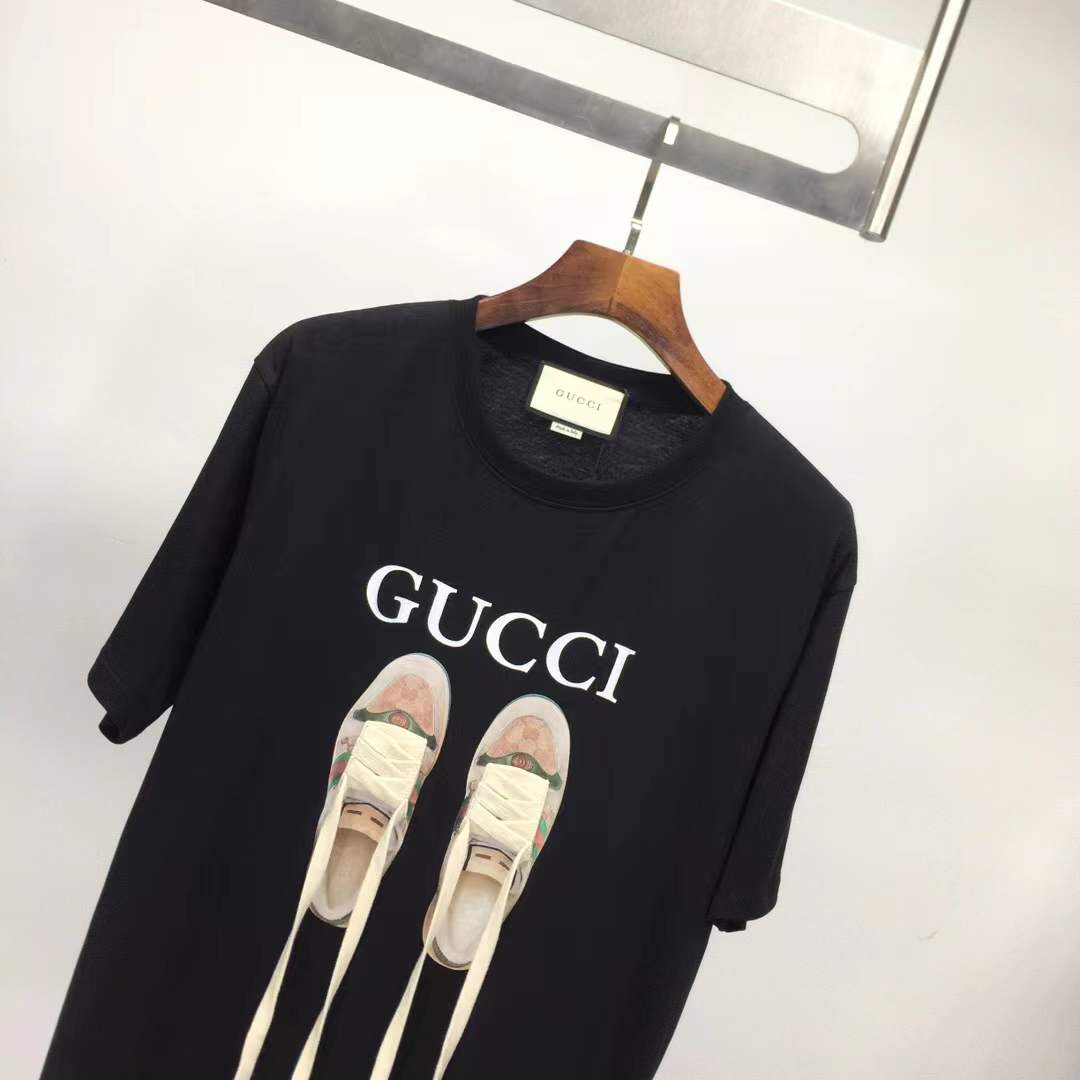 Gucci black t-shirt featuring a printed graphic of shoes with hanging shoelaces