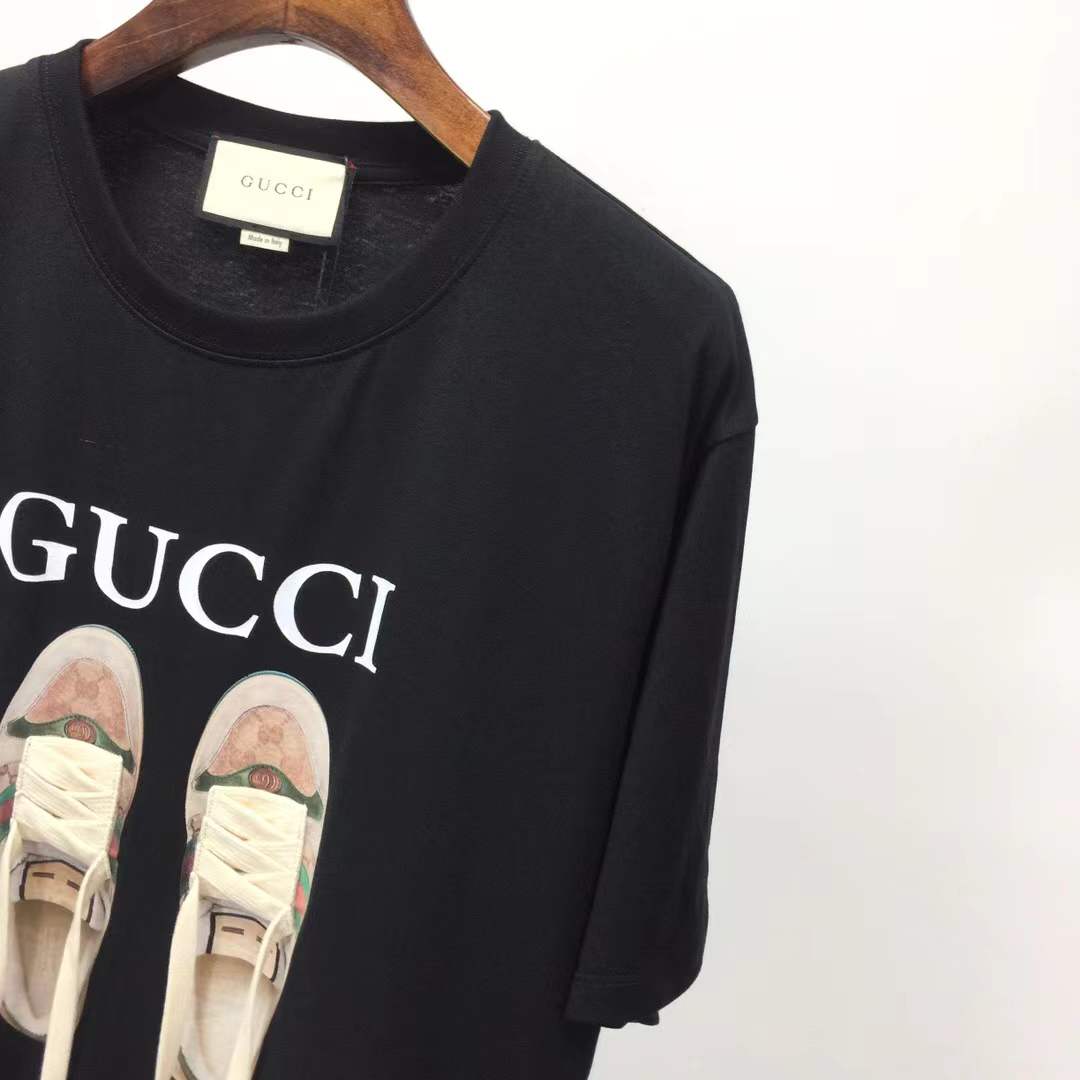 Gucci black t-shirt featuring a printed graphic of shoes with hanging shoelaces