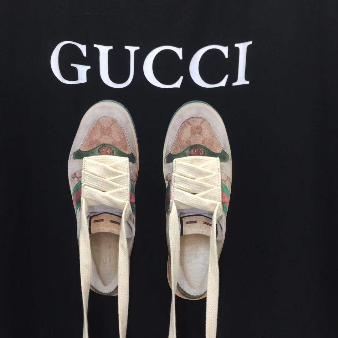 Gucci black t-shirt featuring a printed graphic of shoes with hanging shoelaces