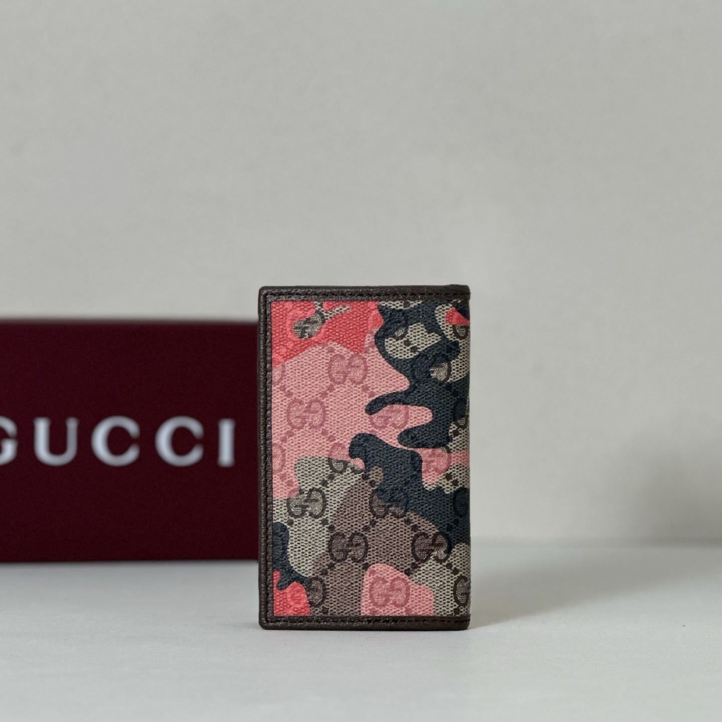 Gucci wallet featuring a camouflage design over the iconic GG Supreme canvas pattern
