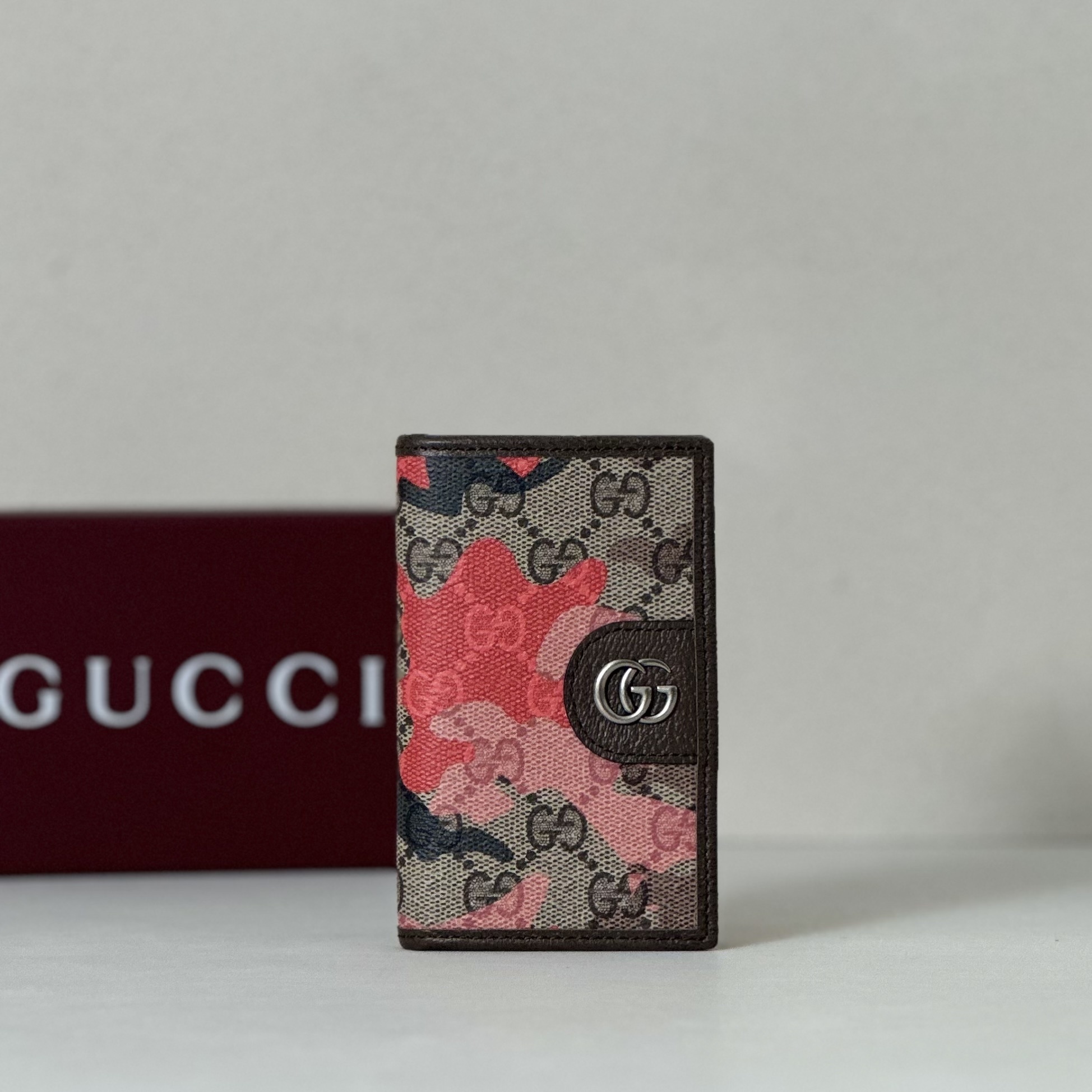 Gucci wallet featuring a camouflage design over the iconic GG Supreme canvas pattern