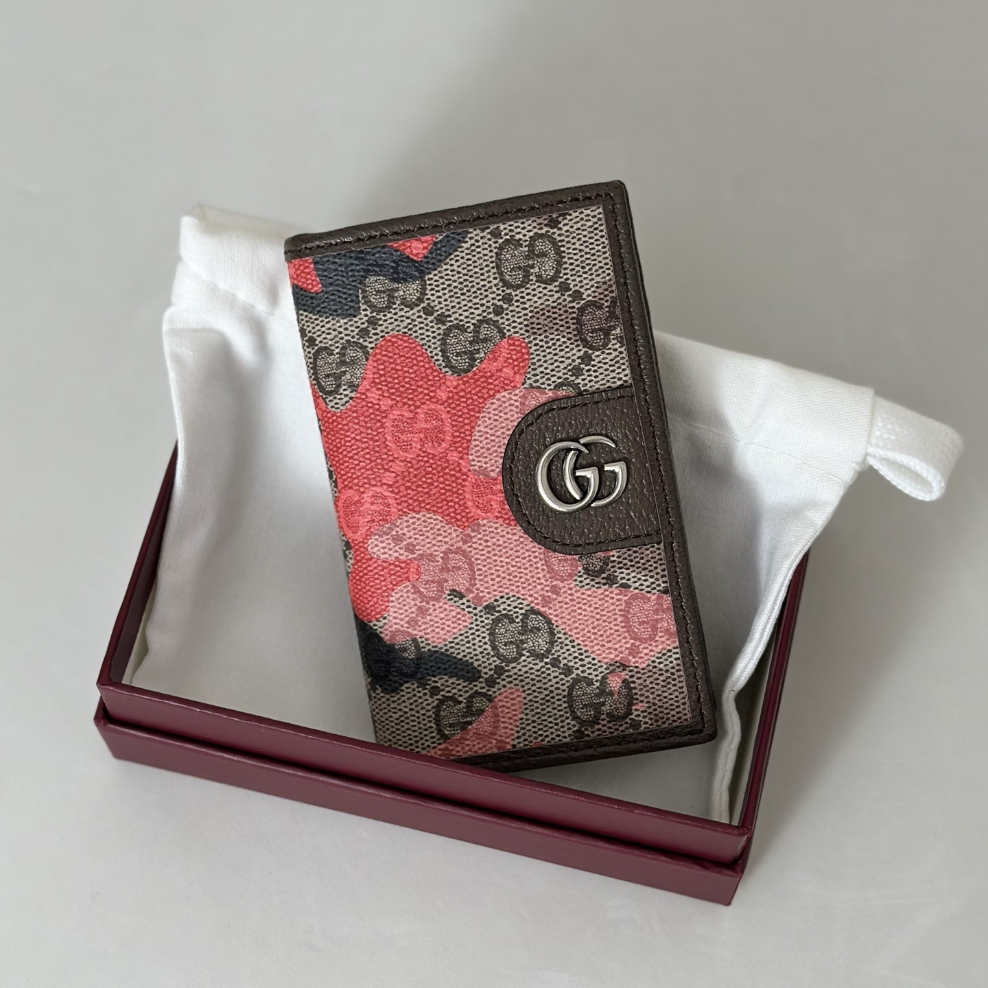 Gucci wallet featuring a camouflage design over the iconic GG Supreme canvas pattern