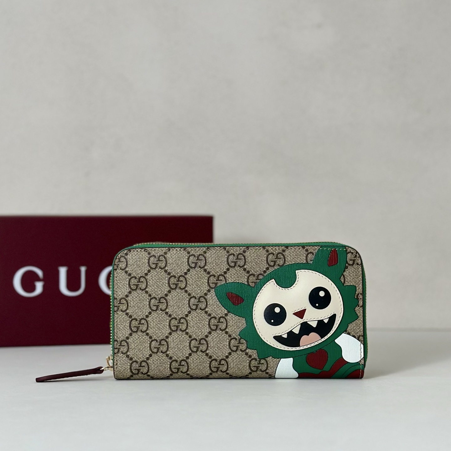 Gucci GG Supreme canvas zip-around wallet featuring a whimsical creature print