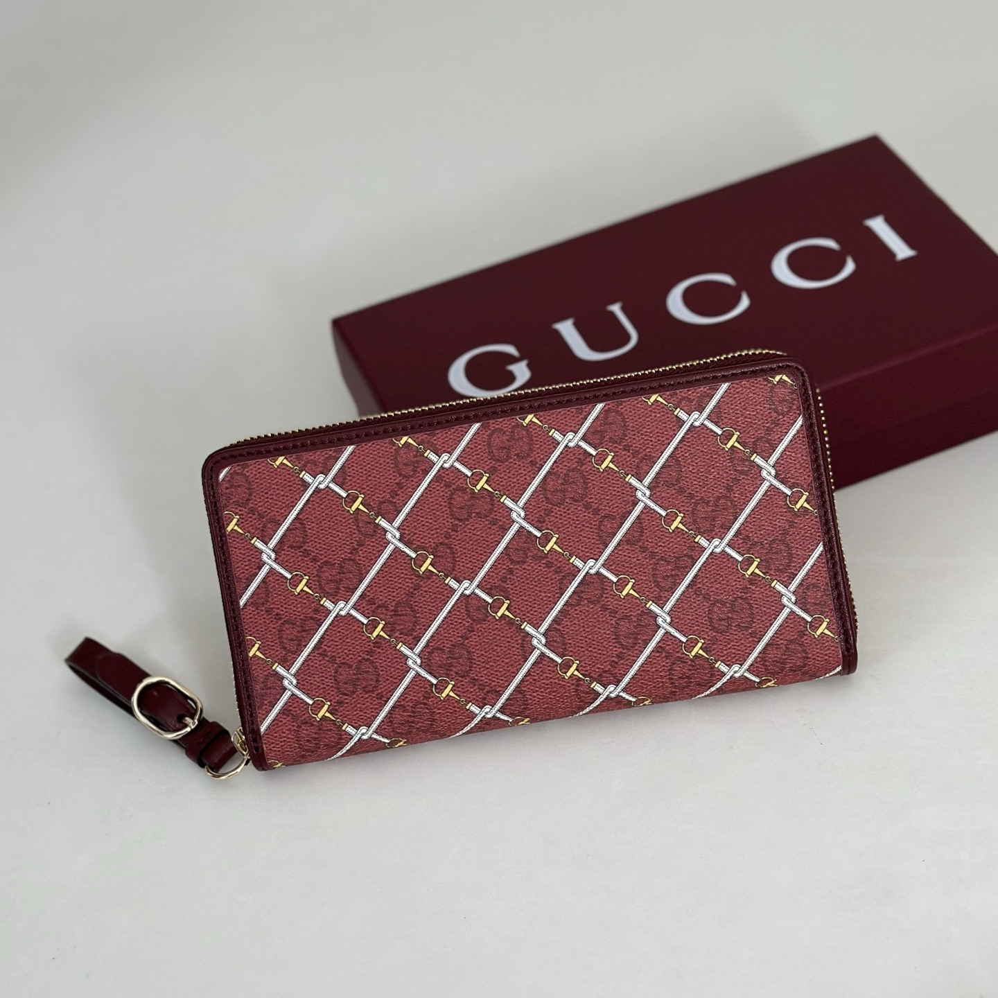 Gucci Printed GG zip around wallet featuring a laminated-effect fabric with a Horsebit print