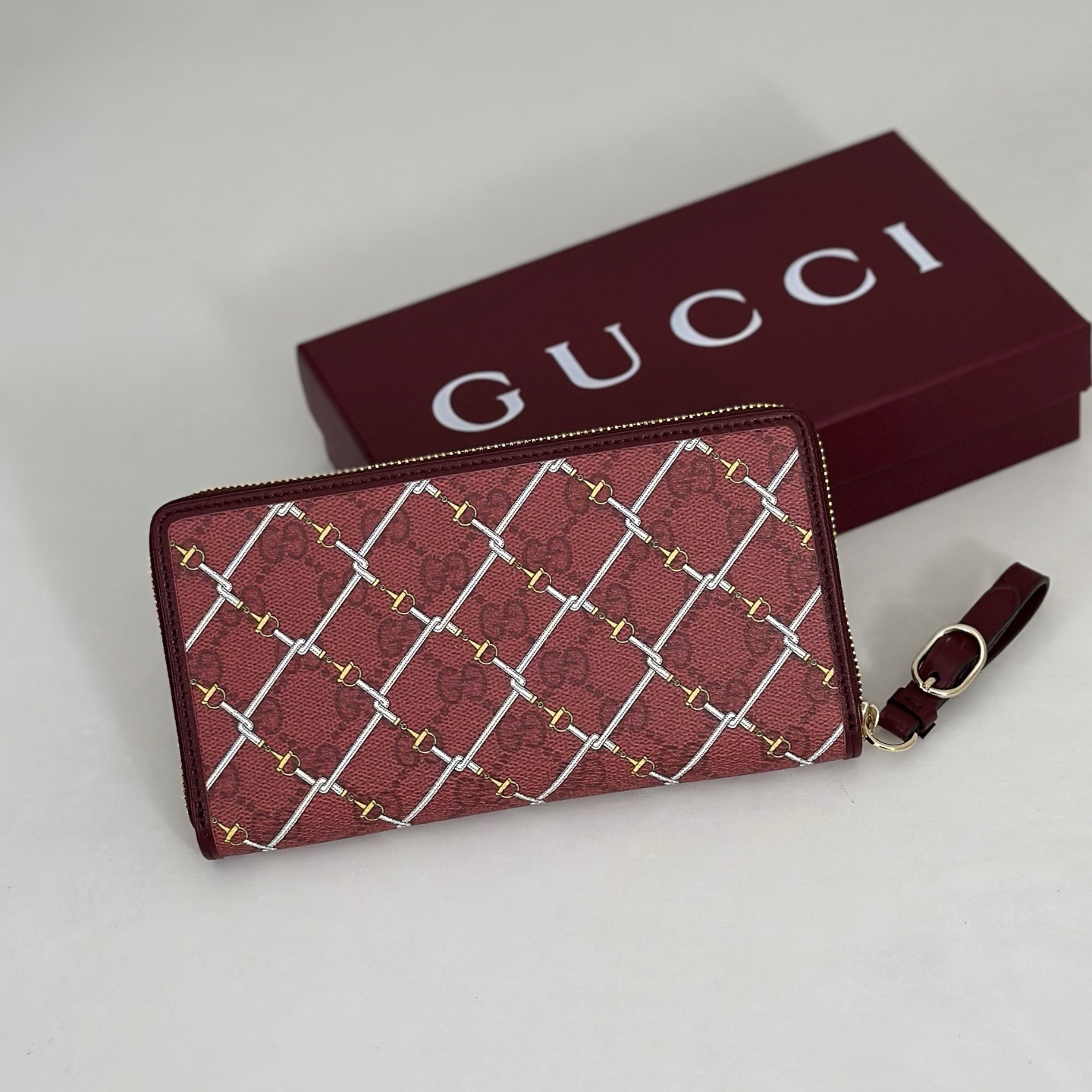Gucci Printed GG zip around wallet featuring a laminated-effect fabric with a Horsebit print