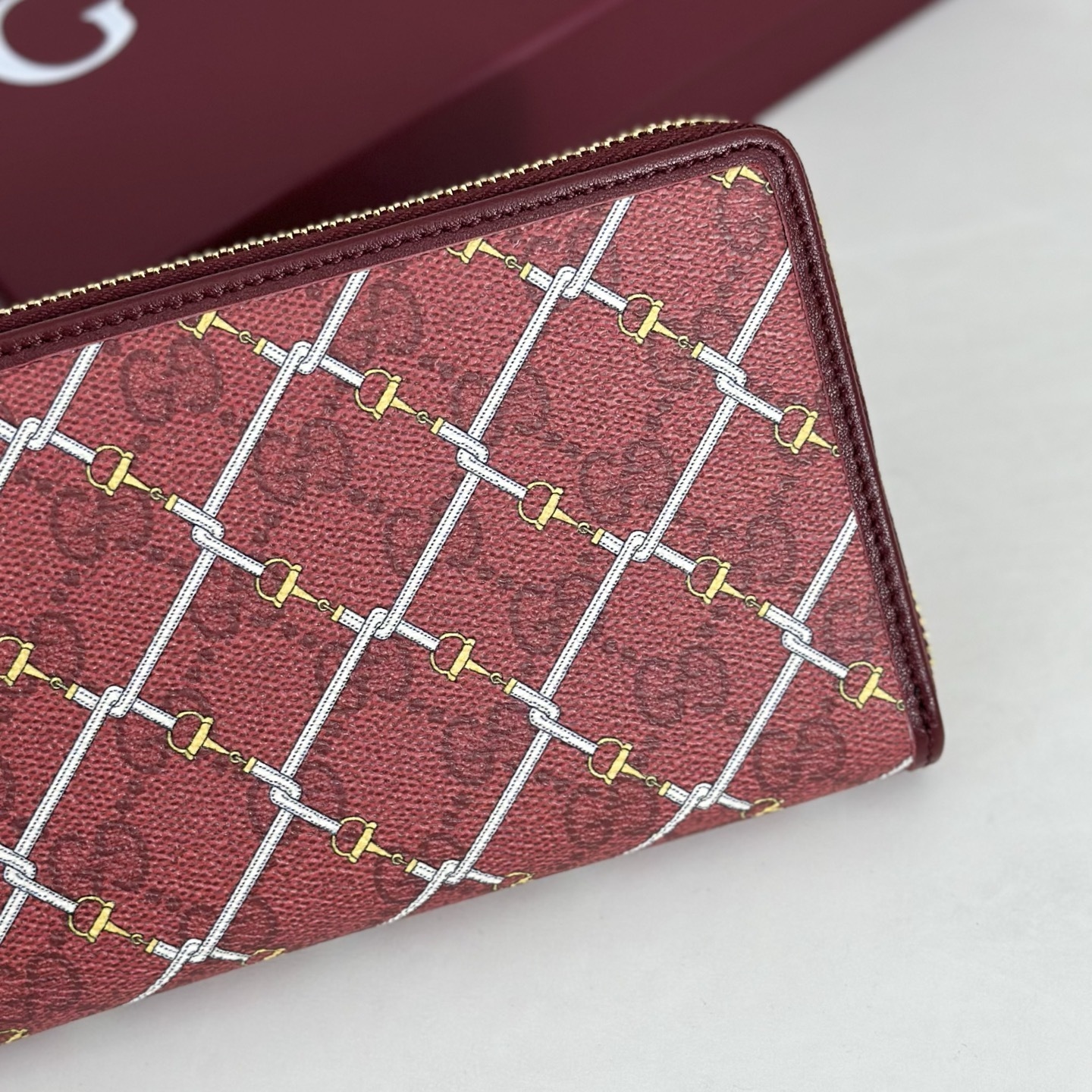 Gucci Printed GG zip around wallet featuring a laminated-effect fabric with a Horsebit print
