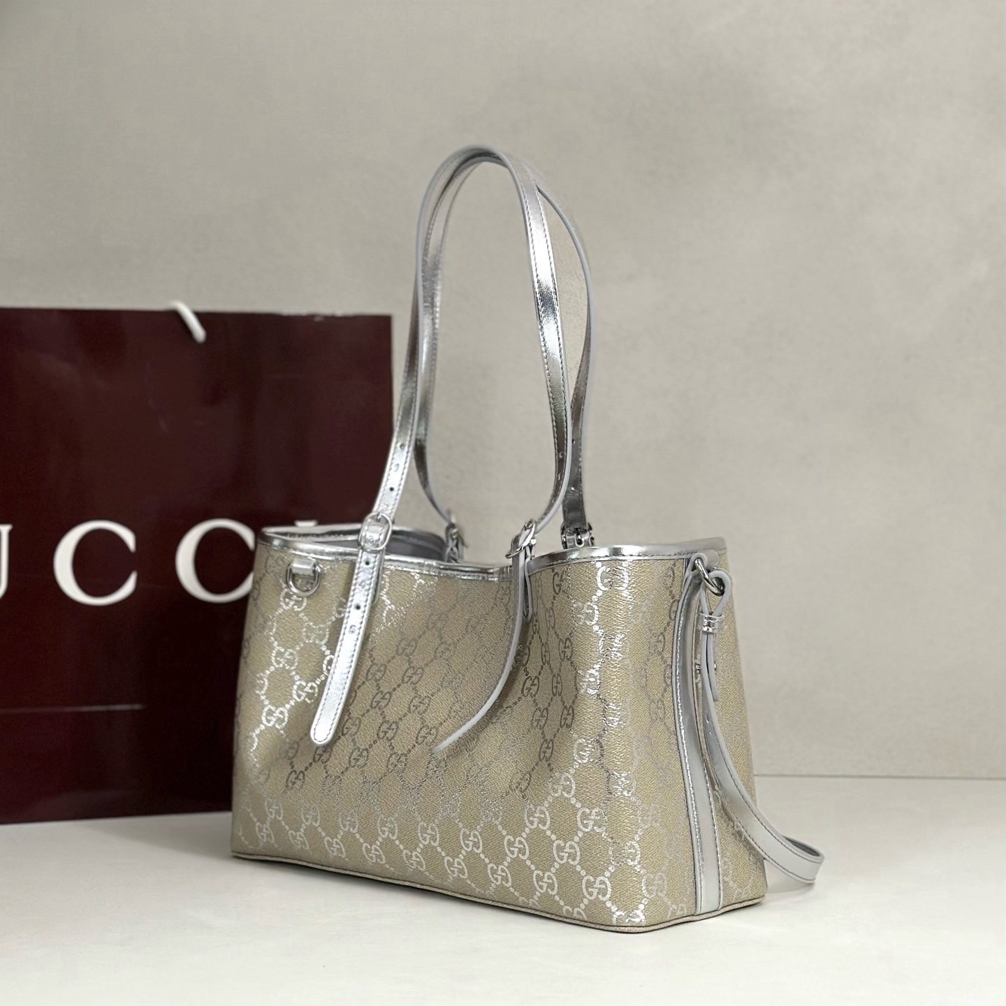 Gucci GG Emblem medium tote bag featuring light beige and metallic silver laminated-effect GG monogram coated fabric with metallic silver leather trim