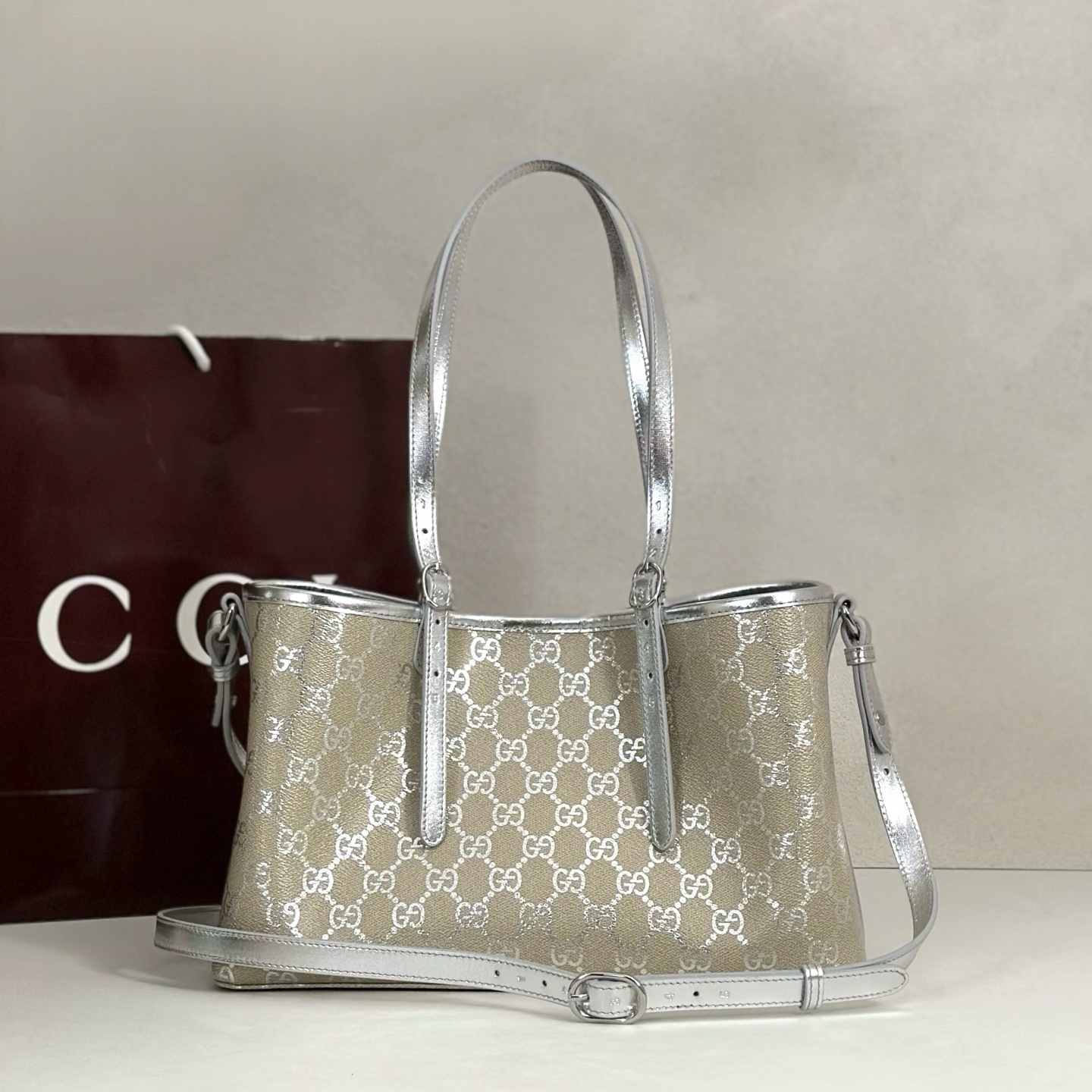 Gucci GG Emblem medium tote bag featuring light beige and metallic silver laminated-effect GG monogram coated fabric with metallic silver leather trim