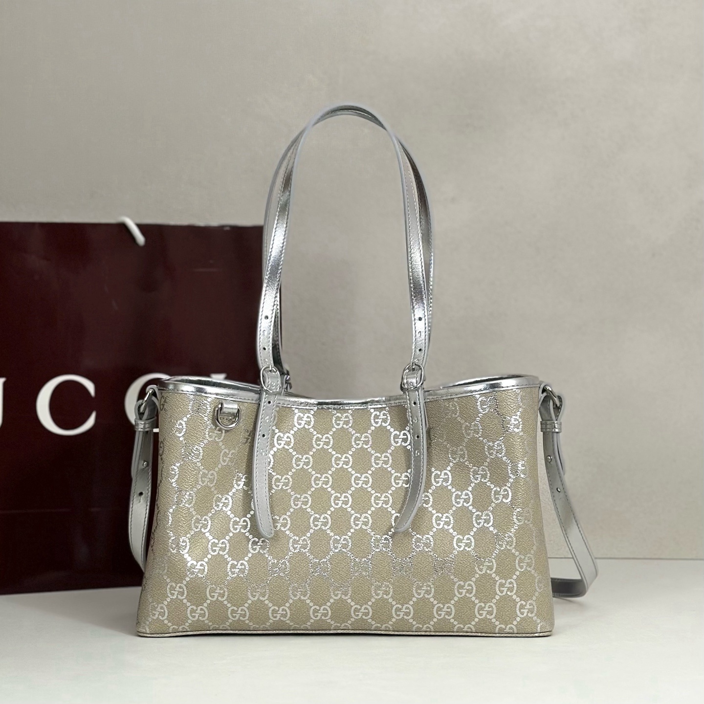 Gucci GG Emblem medium tote bag featuring light beige and metallic silver laminated-effect GG monogram coated fabric with metallic silver leather trim