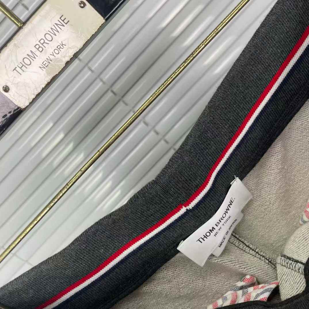 Thom Browne men's gray cotton jersey sweatpants featuring a color-block design and the signature 4-bar stripe detail on the side
