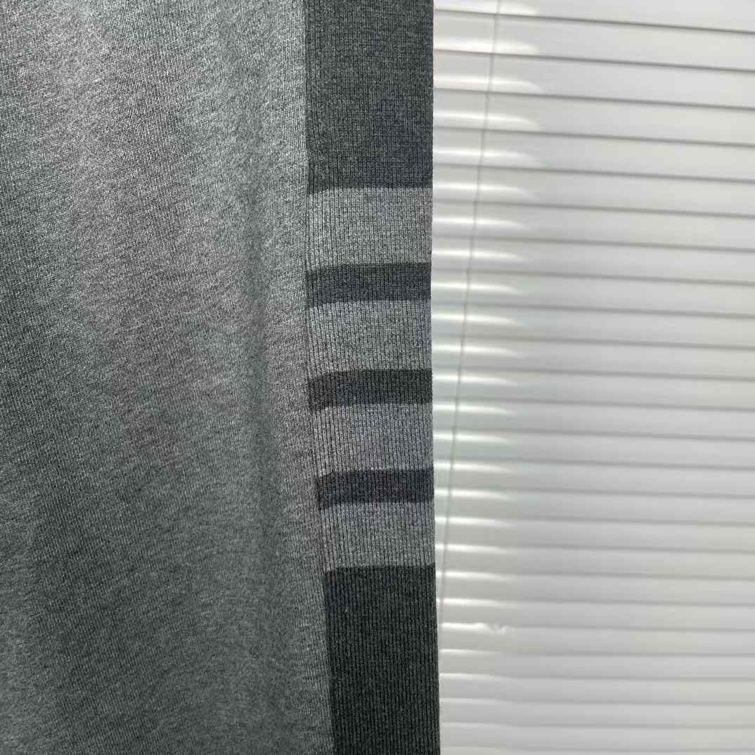 Thom Browne men's gray cotton jersey sweatpants featuring a color-block design and the signature 4-bar stripe detail on the side