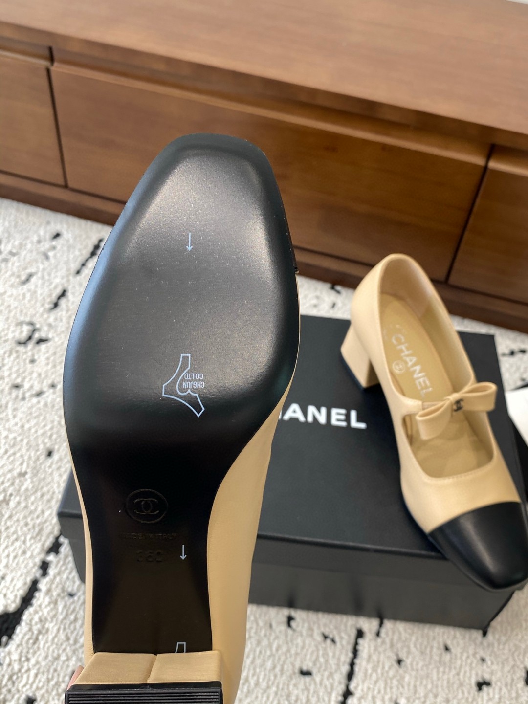 Chanel Mary Jane heels are designed in a classic two-tone beige and black leather style with a sturdy block heel and a ribbon strap detail.