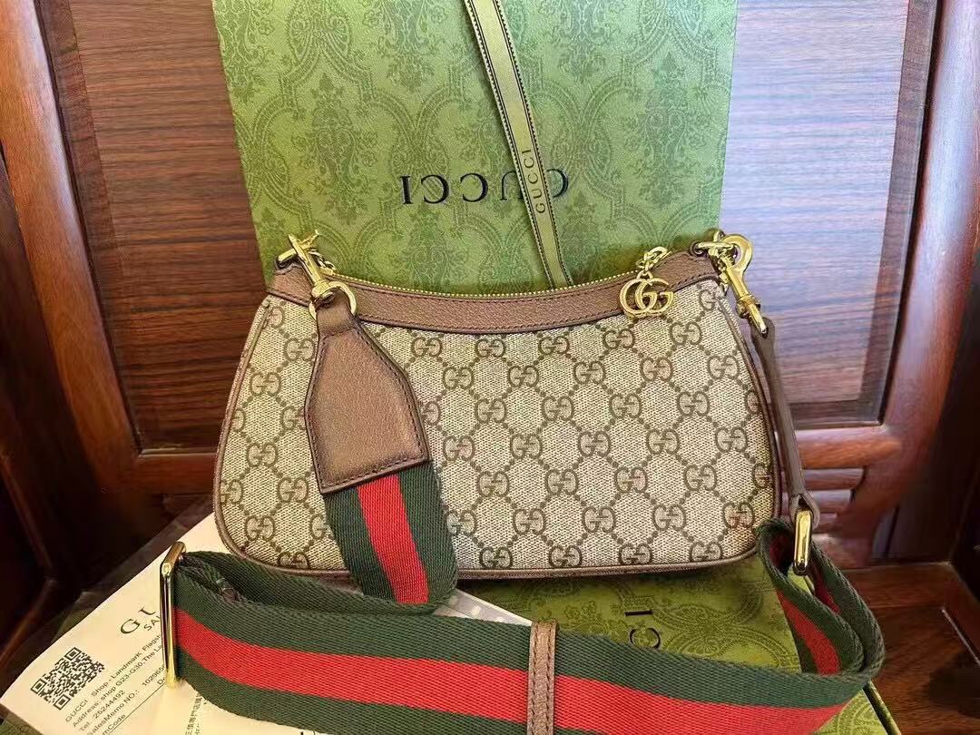 Gucci Ophidia GG Small Handbag in beige and ebony Supreme canvas features leather trim, the iconic green and red Web stripe, and a chain strap