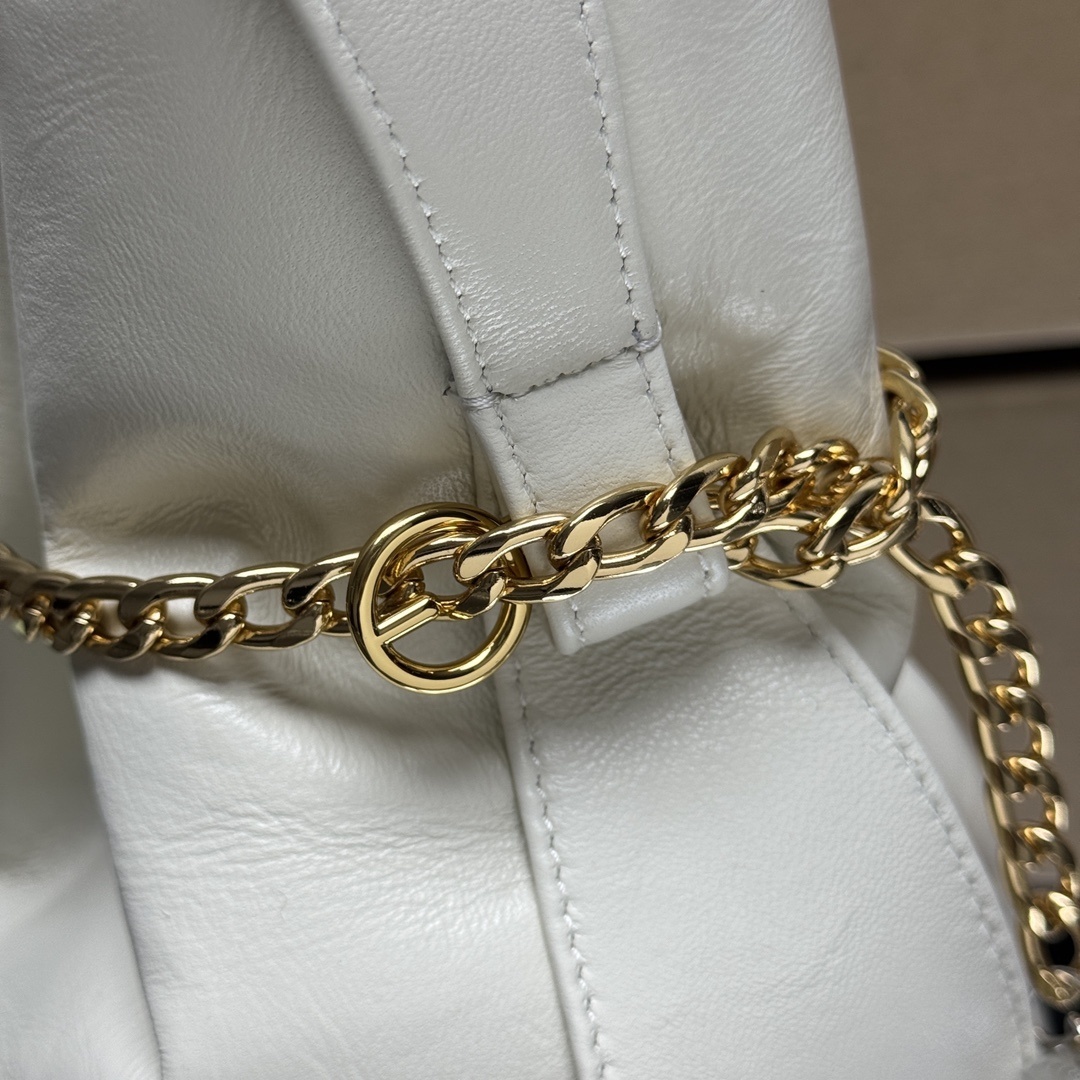 Prada Petit Sac Noir mini bucket bag is crafted from white nappa leather and features a gold-tone chain closure, a matching top handle, and a metallic sphere charm