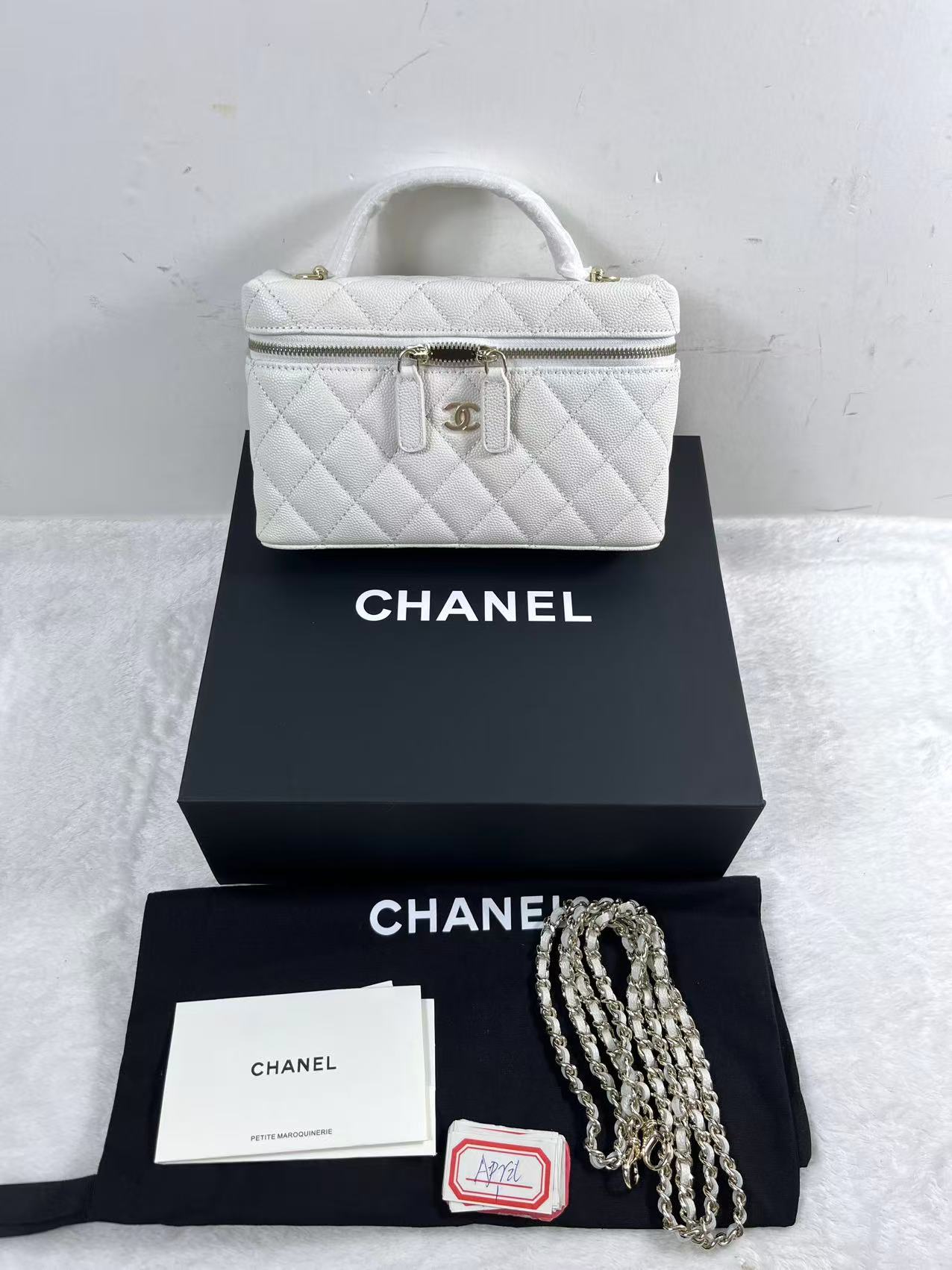 Chanel vanity case likely crafted from white quilted caviar leather featuring gold-tone hardware