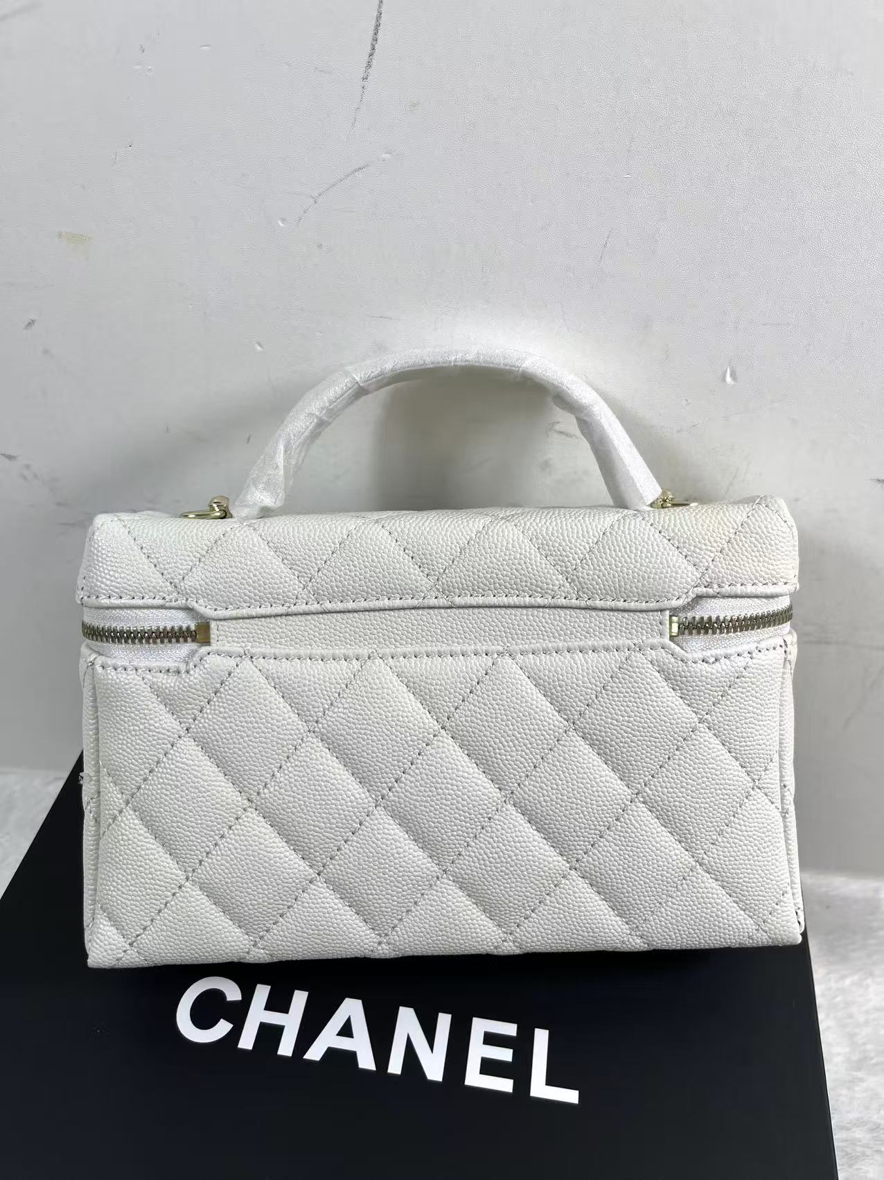 Chanel vanity case likely crafted from white quilted caviar leather featuring gold-tone hardware