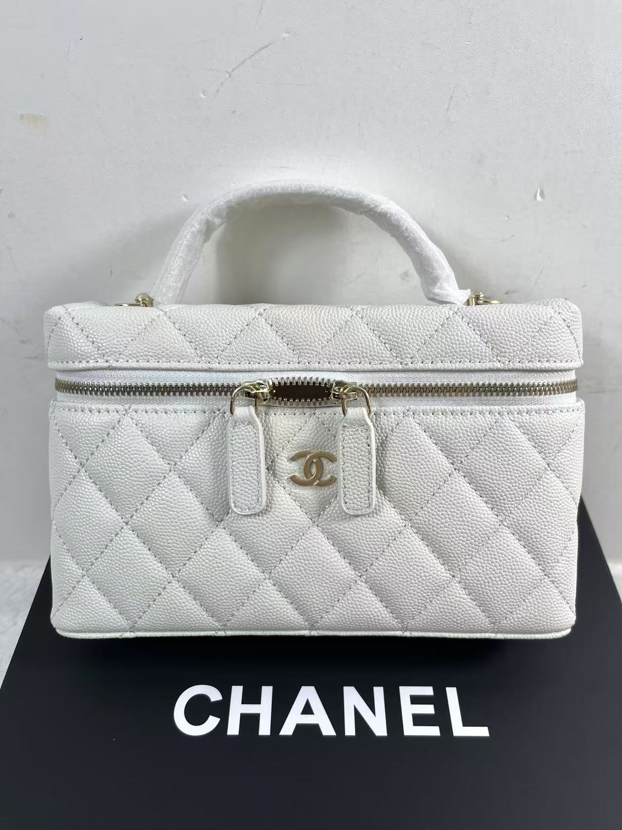 Chanel vanity case likely crafted from white quilted caviar leather featuring gold-tone hardware