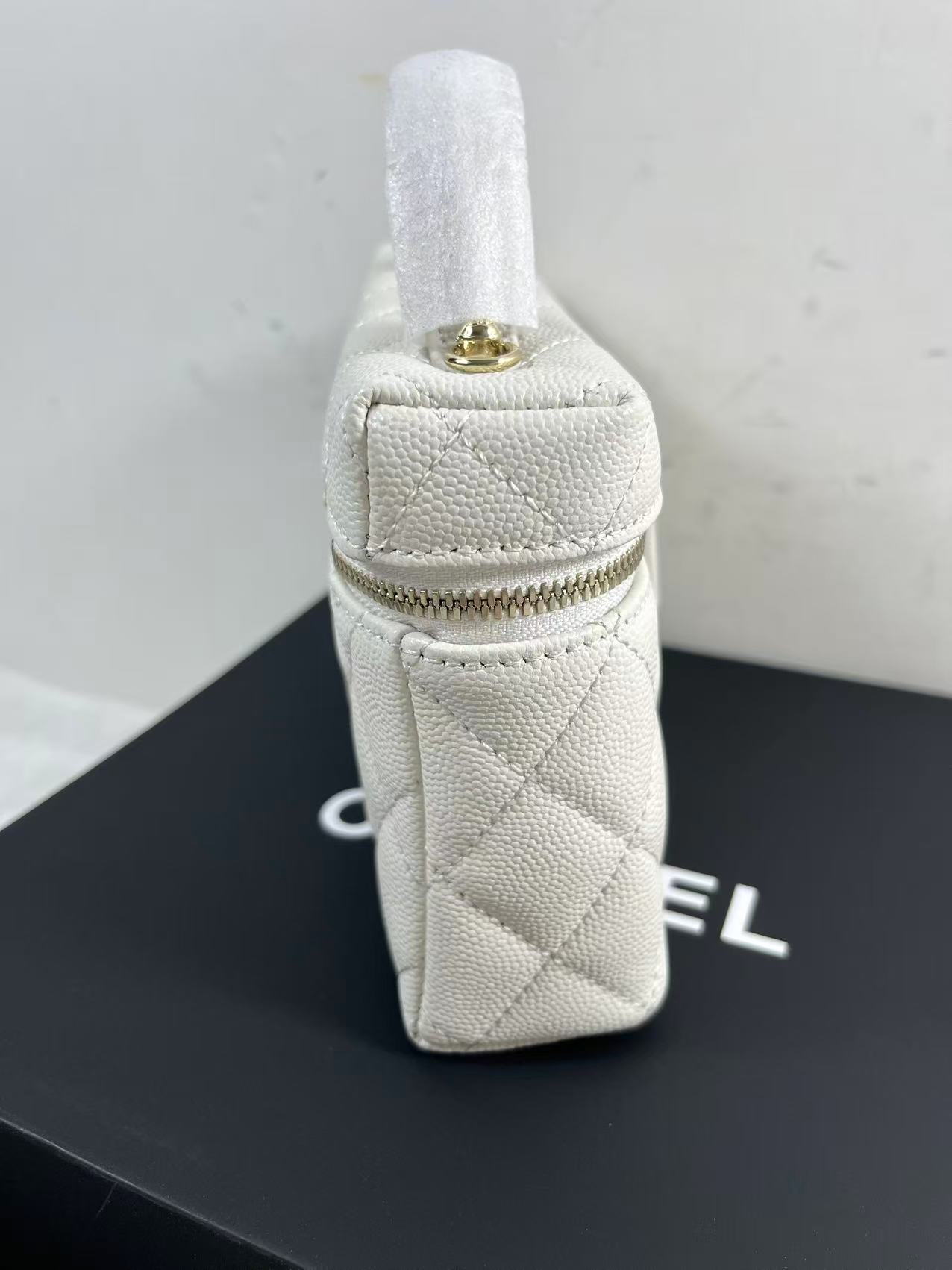 Chanel vanity case likely crafted from white quilted caviar leather featuring gold-tone hardware